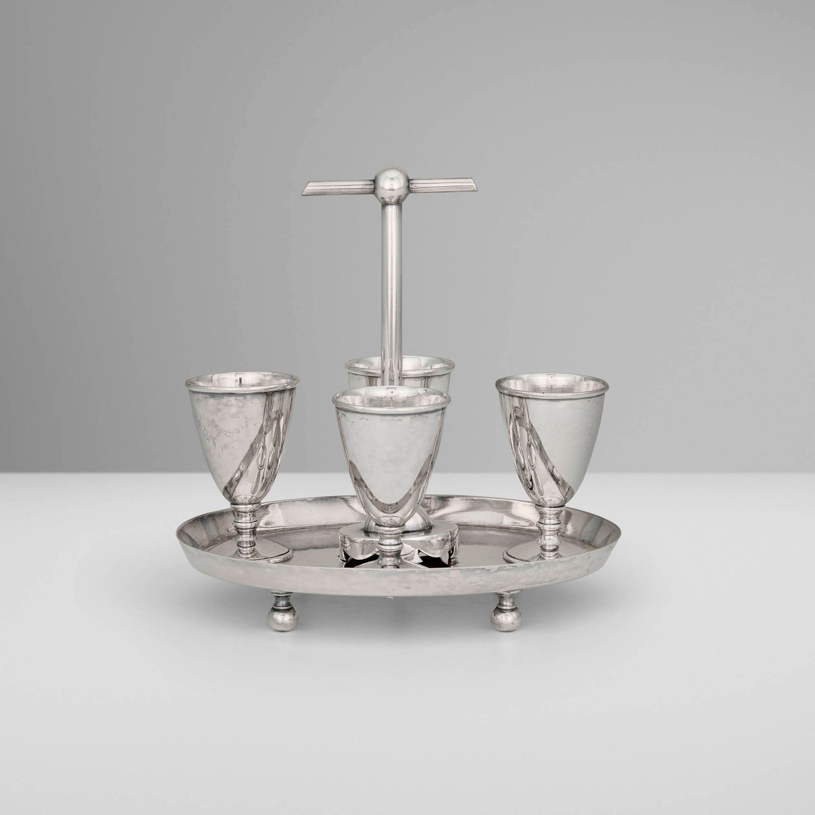 Christopher Dresser, Egg cups, set of four with holder: Christopher Dresser Egg cups, set of four with holder Hukin & Heath United Kingdom, c. 1880 silver-plated metal 7 h x 7 w x 5 d in (18 x 18 x 13 cm) 2.75 h x 1.75 w in (7 x 4 cm) Impressed maker's