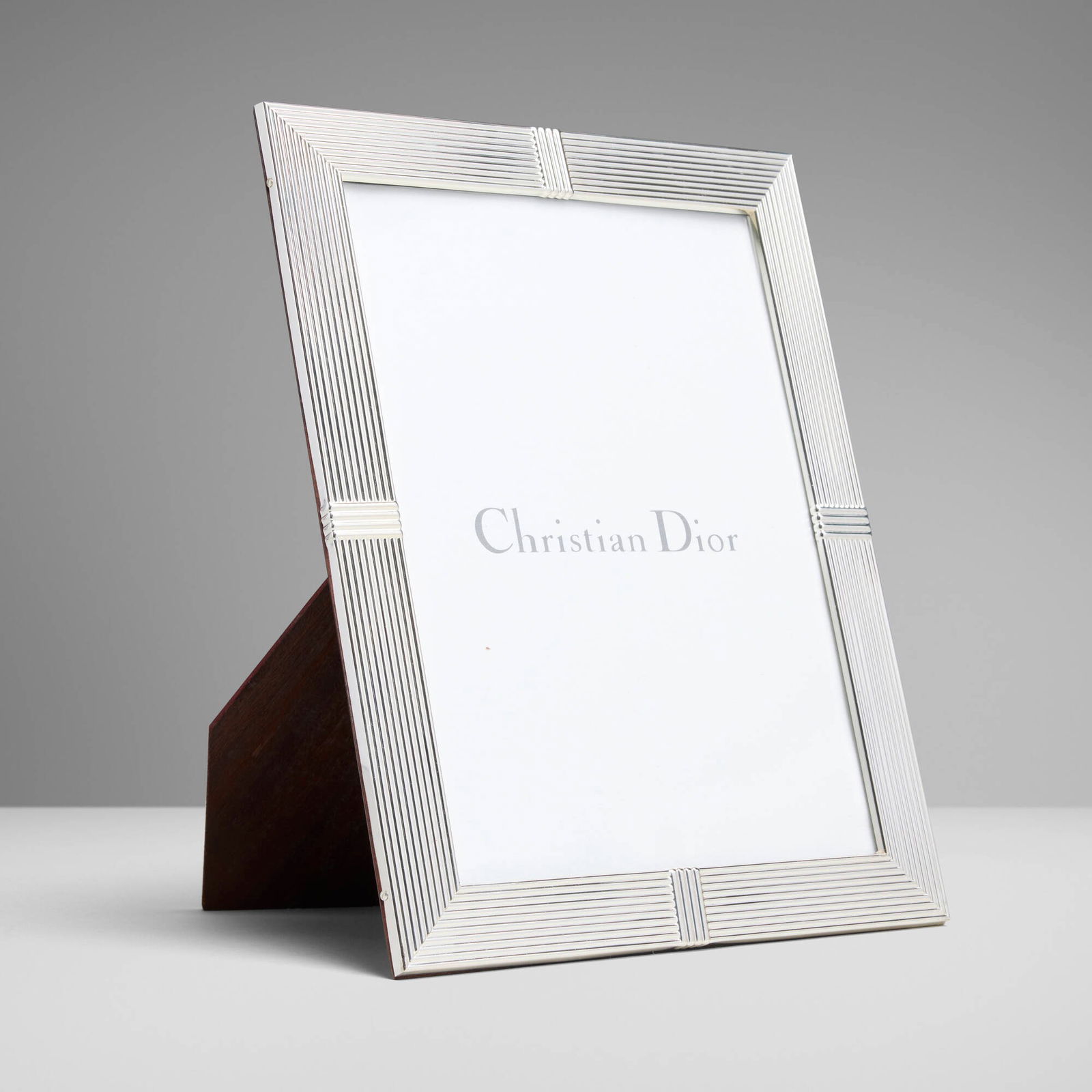 Christian Dior, Picture frame: Christian Dior Picture frame France/Italy, c. 1990 silver-plated metal, mahogany 11.25 h x 8.75 w x 0.5 d in (29 x 22 x 1 cm) Impressed manufacturer's mark to reverse 'CD' and 'Christian Dior Made