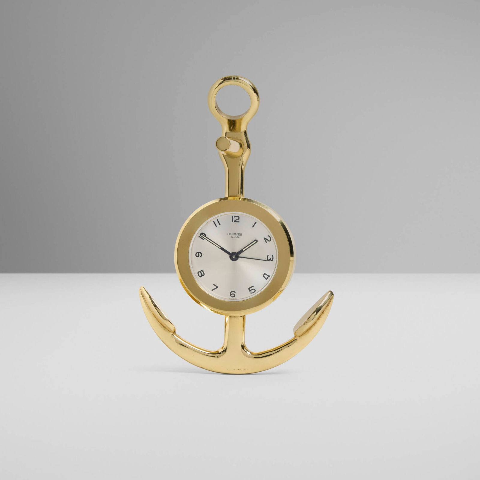 Hermes, Anchor table clock: Hermes Anchor table clock France / Switzerland, c. 1970 gold-plated brass 6.5 h x 4.25 w x 2.5 d in (17 x 11 x 6 cm) Printed manufacturer's mark to dial 'Hermes Paris Swiss'. This work will ship