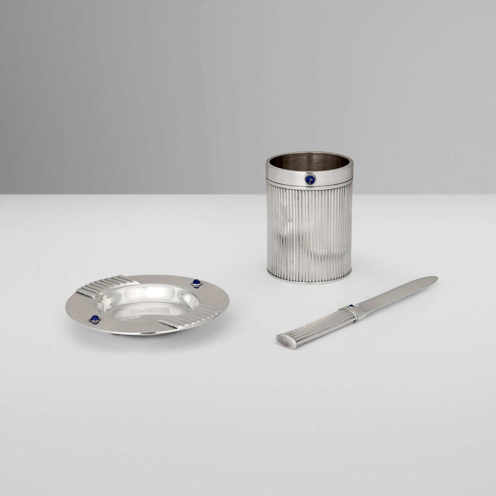 Cartier, Lapis Collection tabletop accessories, set of three: Cartier Lapis Collection tabletop accessories, set of three France / Spain, c. 1990silver-plated metal, lapis lazuli 3.75 h x 2.75 dia in (10 x 7 cm) 0.75 h x 4.75 dia in (2 x 12 cm) 7.25 h x 0