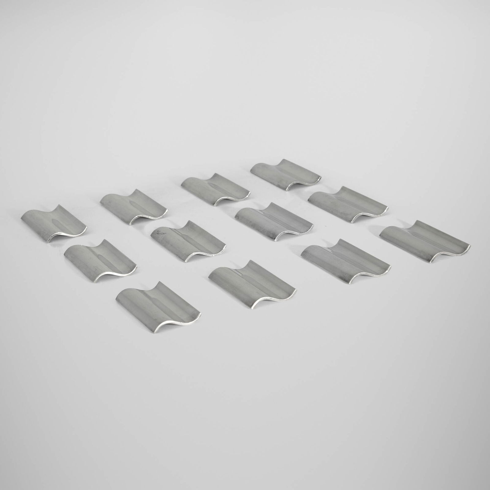 Ravinet d'Enfert & Cie, Knife rests, set of twelve: Ravinet d'Enfert & Cie Knife rests, set of twelve France, c. 1965 silver-plated metal 0.25 h x 2.625 w x 1.25 d in (1 x 7 x 3 cm) Impressed manufacturer's mark to each example 'Ravinet d'Enfert