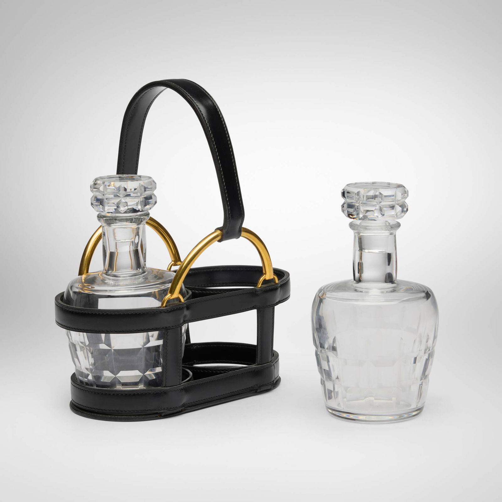 Hermes, Decanter set: Hermes Decanter set Baccarat France, c. 1950 crystal, leather, brass 9.75 h x 8.25 w x 5.25 d in (25 x 21 x 13 cm) Embossed and gilt manufacturer's mark to underside of leather case 'Hermes