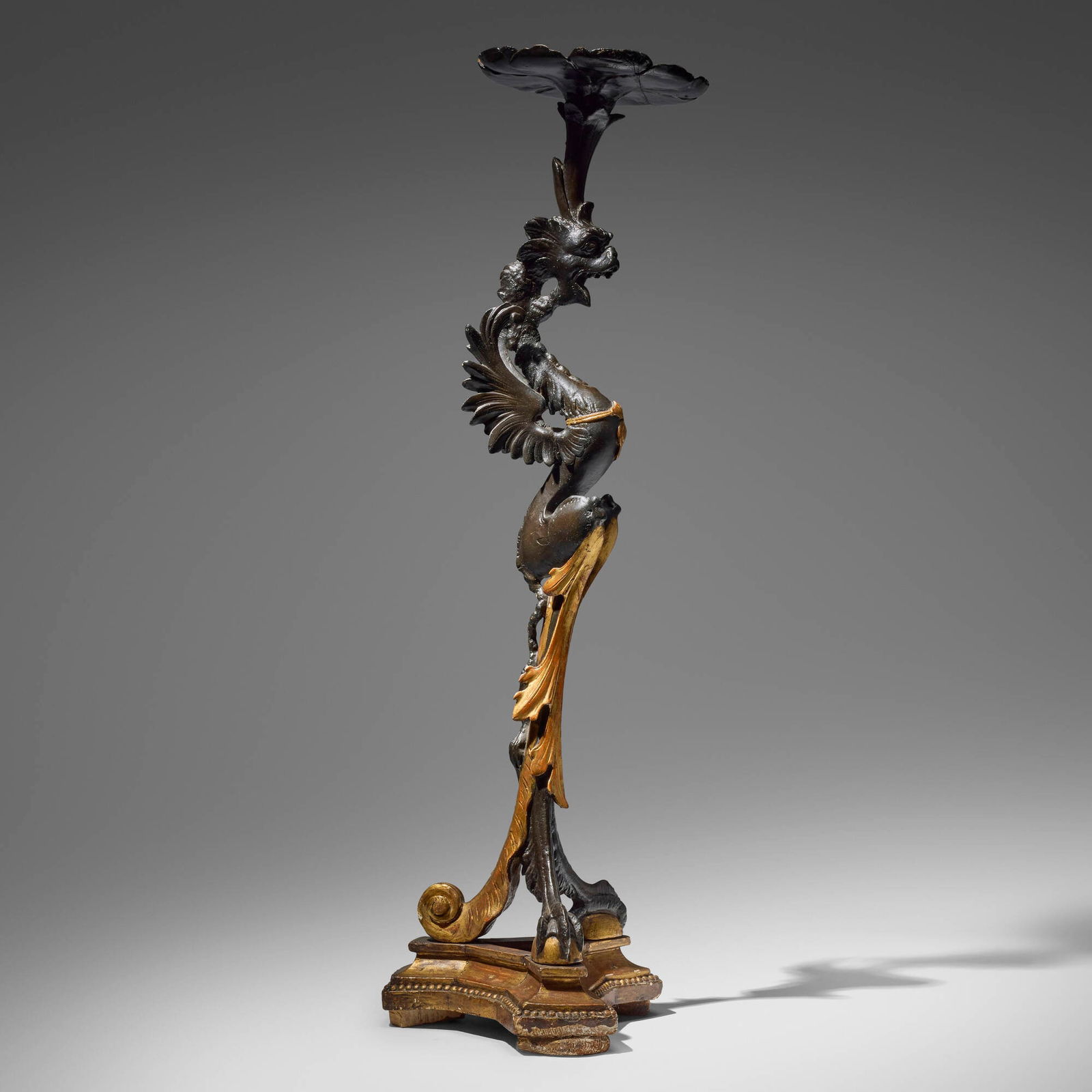Rococo Style, Winged griffin torchere: Rococo Style Winged griffin torchere 19th century parcel gilt and ebonized plaster and wood 39.5 h x 12.5 dia in (100 x 32 cm) Provenance: Bonham's, San Francisco, Period Art & Design, 11 May