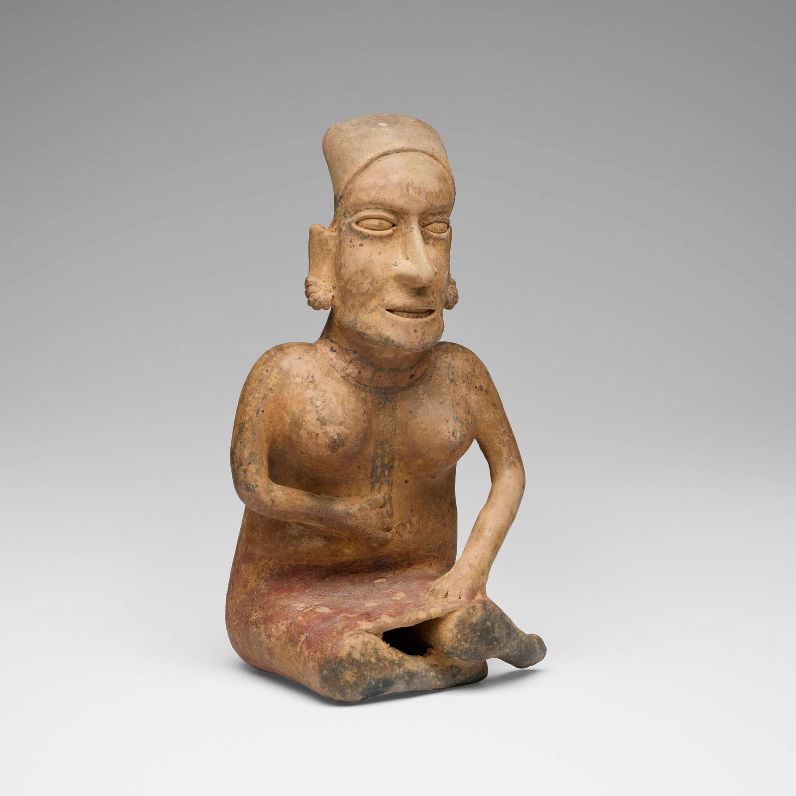 Jalisco, Seated female figure: Jalisco Seated female figure Protoclassic, c. 100 BCE-250 CE terracotta with ochre pigment 13.75 h x 8 w x 6.5 d in (35 x 20 x 17 cm) Provenance: Carlebach Gallery, Inc., New York | Acquired from