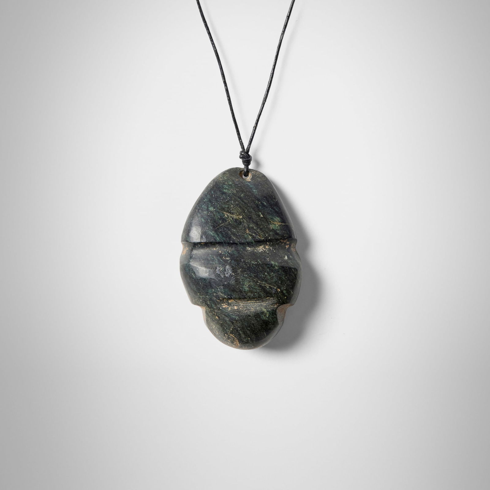 Mezcala, Pendant: Mezcala Pendant Guerrero, Mexico, 250-650 CE stone, leather cord pendant: 2.5 h x 1.625 w x 0.625 d in (6 x 4 x 2 cm) Provenance: Gift from B.C. (Bud) Holland, Chicago to the present owner This