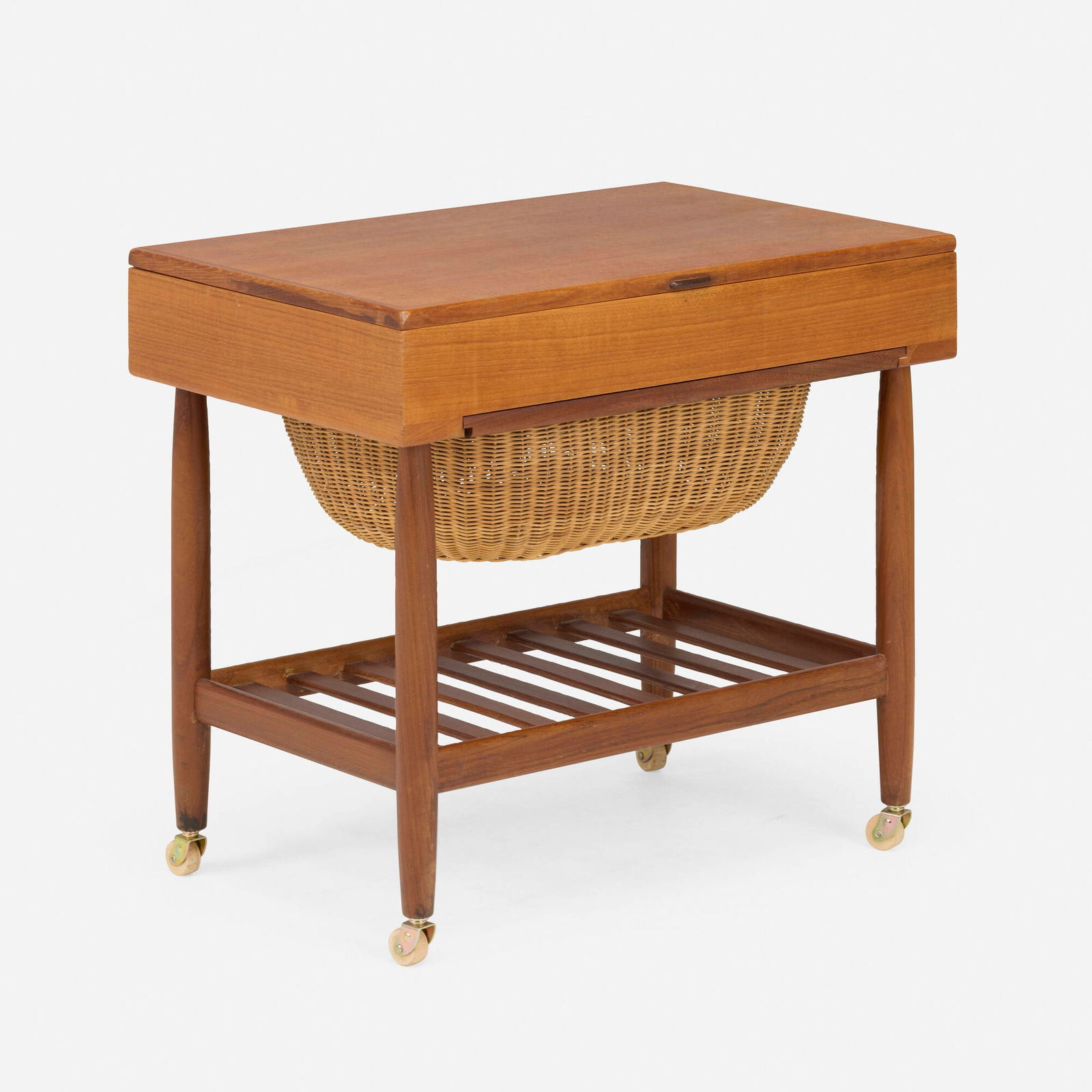 Ejvind A. Johansson, Sewing table: Ejvind A. Johansson Sewing table FDB Mobler Denmark, c. 1965 teak, walnut, rattan, casters 22.5 h x 23.75 w x 16 d in (57 x 60 x 41 cm) Table features a hinged top concealing divided storage over