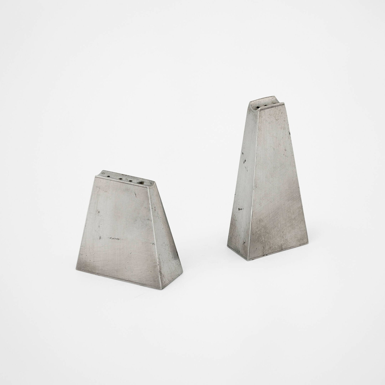 Paul Evans, Salt and pepper shakers, pair: Paul Evans Salt and pepper shakers, pair USA, c. 1955 pewter 3 h x 1.5 w x 0.75 d in (8 x 4 x 2 cm) 2 h x 2 w x 0.875 d in (5 x 5 x 2 cm) Impressed distributor's mark to underside of each