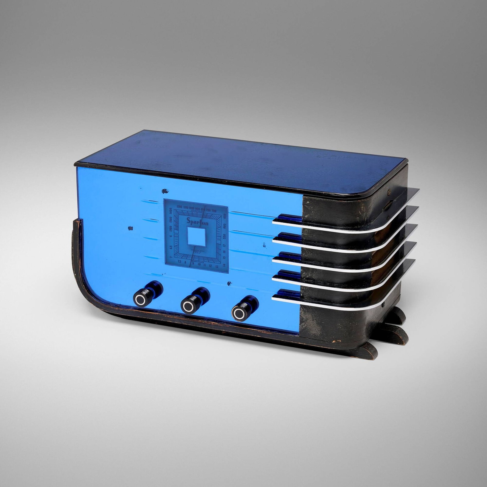 Walter Dorwin Teague, Sparton radio, model 557: Walter Dorwin Teague Sparton radio, model 557 Sparks Withington Company USA, c. 1936 midnight blue Tuf-Flex mirrored glass, chrome-plated steel, lacquered wood, Bakelite 8.875 h x 18 w x 8.5 d in (23