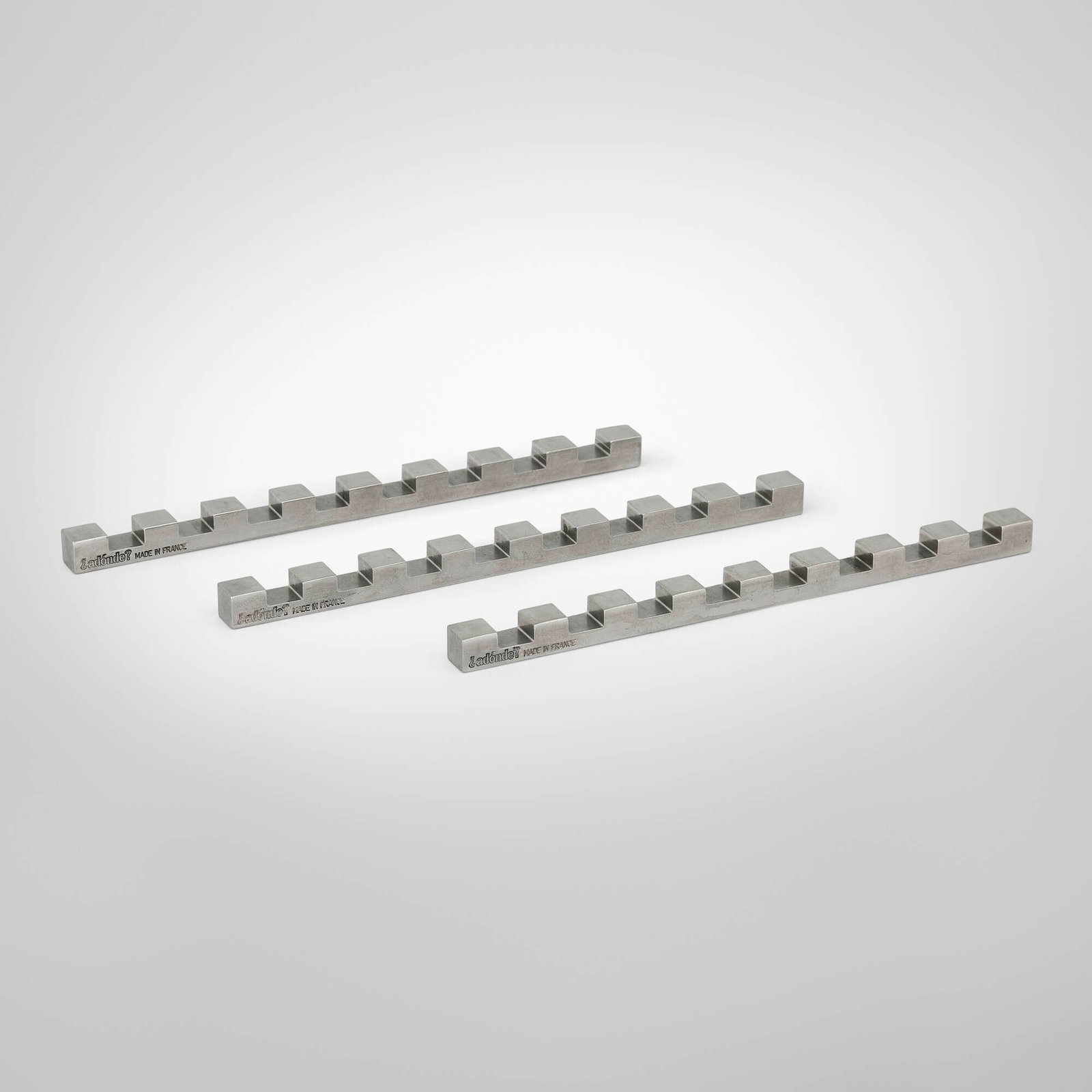 adonde, Knife rests, set of three: adonde Knife rests, set of three France, 21st century stainless steel 0.375 h x 6.75 w x 0.375 d in (1 x 17 x 1 cm) Impressed manufacturer's mark to side of each example 'adonde Made in