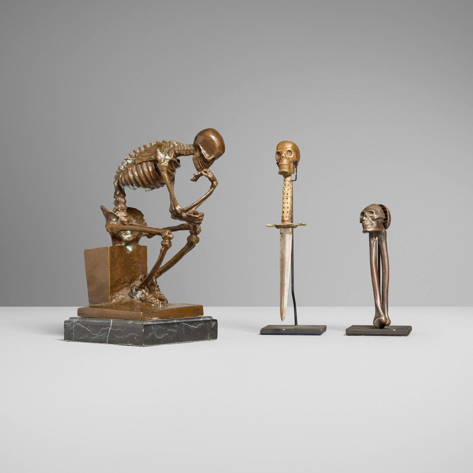 Collection of three memento mori desktop accessories: Collection of three memento mori desktop accessories c. 1900, 1928, 21st century bronzed steel, bronze, resin 10 h x 5.25 w x 6 d in (25 x 13 x 15 cm) 9 h x 2 w x 1.5 d in (23 x 5 x 4 cm) 6 h x 2 w x