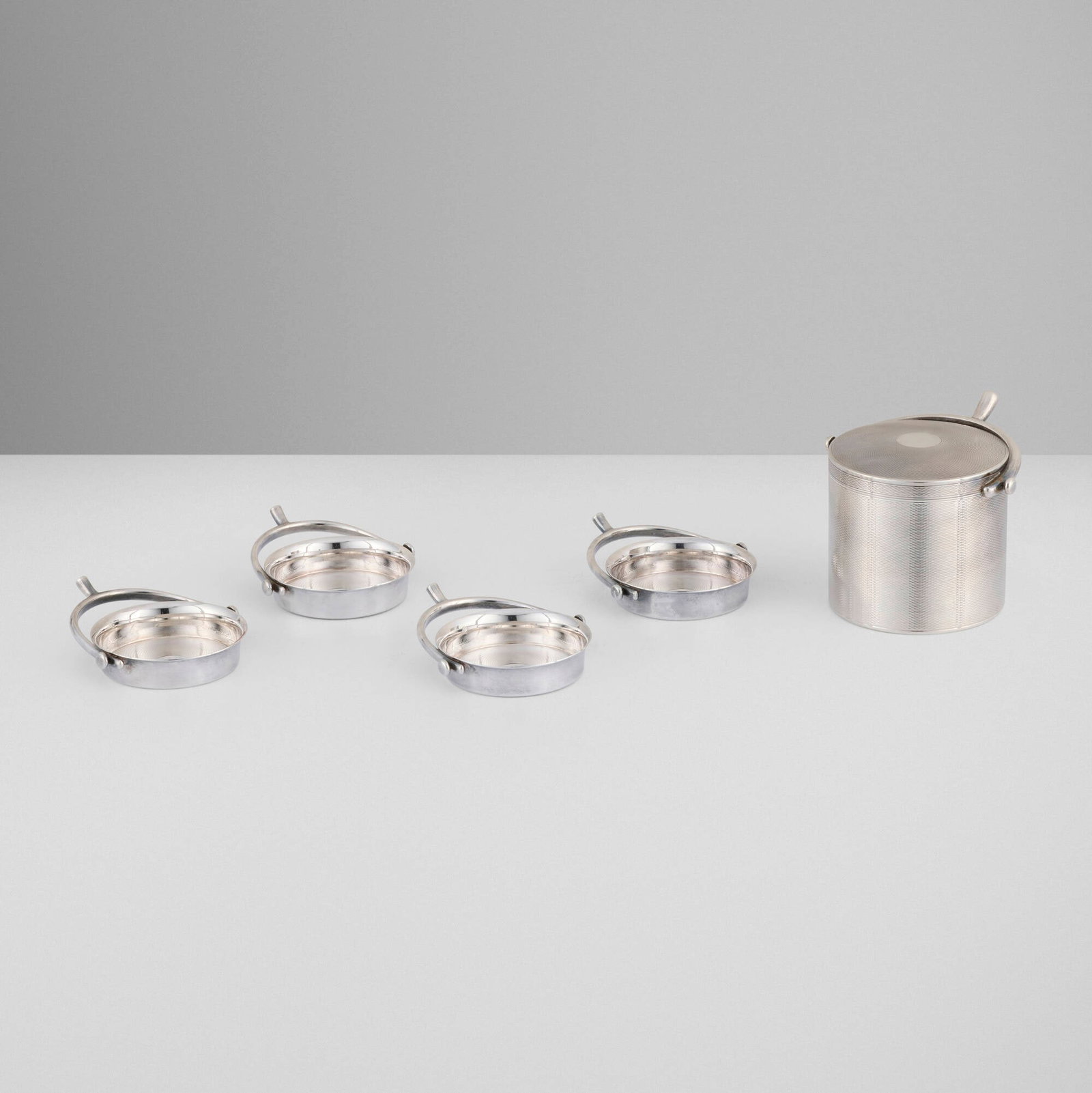 Hermes, Five-piece smoking set with stirrup handles: Hermes Five-piece smoking set with stirrup handles Ravinet d'Enfert & Cie France, c. 1960 .950 silver tobacco container: 3.25 h x 4 dia in (8 x 10 cm) ashtray (each): 1 h x 3.75 w x 3.25 d in (3 x 10