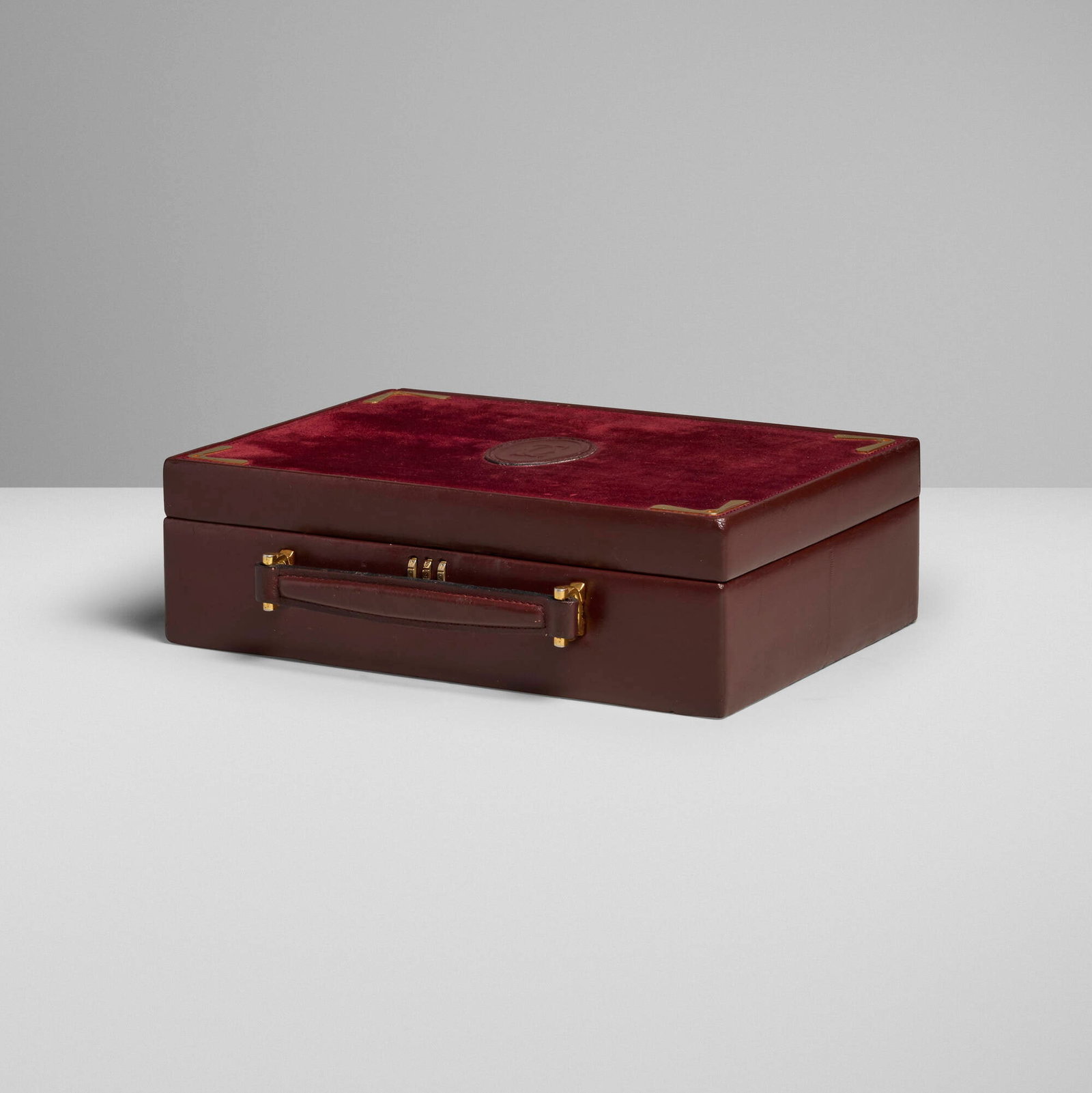 Cartier, Les Must de Cartier travel jewelry box: Cartier Les Must de Cartier travel jewelry box France, c. 1975 leather, suede, brass 3.25 h x 10.75 w x 8.25 d in (8 x 27 x 21 cm) Box features velvet-lined interior compartments. Brass tag man