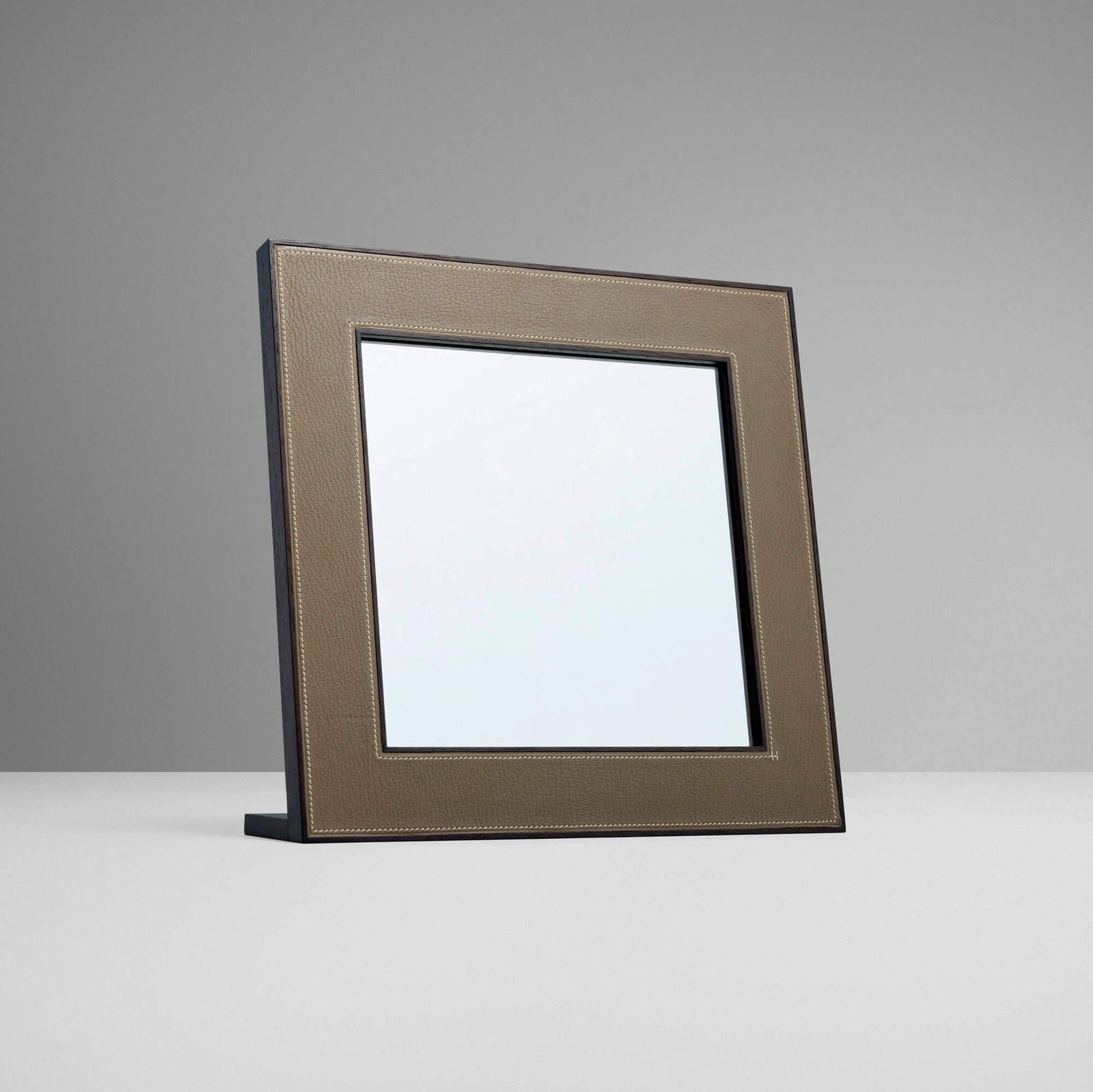 Hermes, Table mirror: Hermes Table mirror France, c. 2000 mahogany, glass, leather 11.75 h x 11.75 w x 3.25 d in (30 x 30 x 8 cm) Impressed manufacturer's mark to reverse 'Hermes'. Sold with original box.