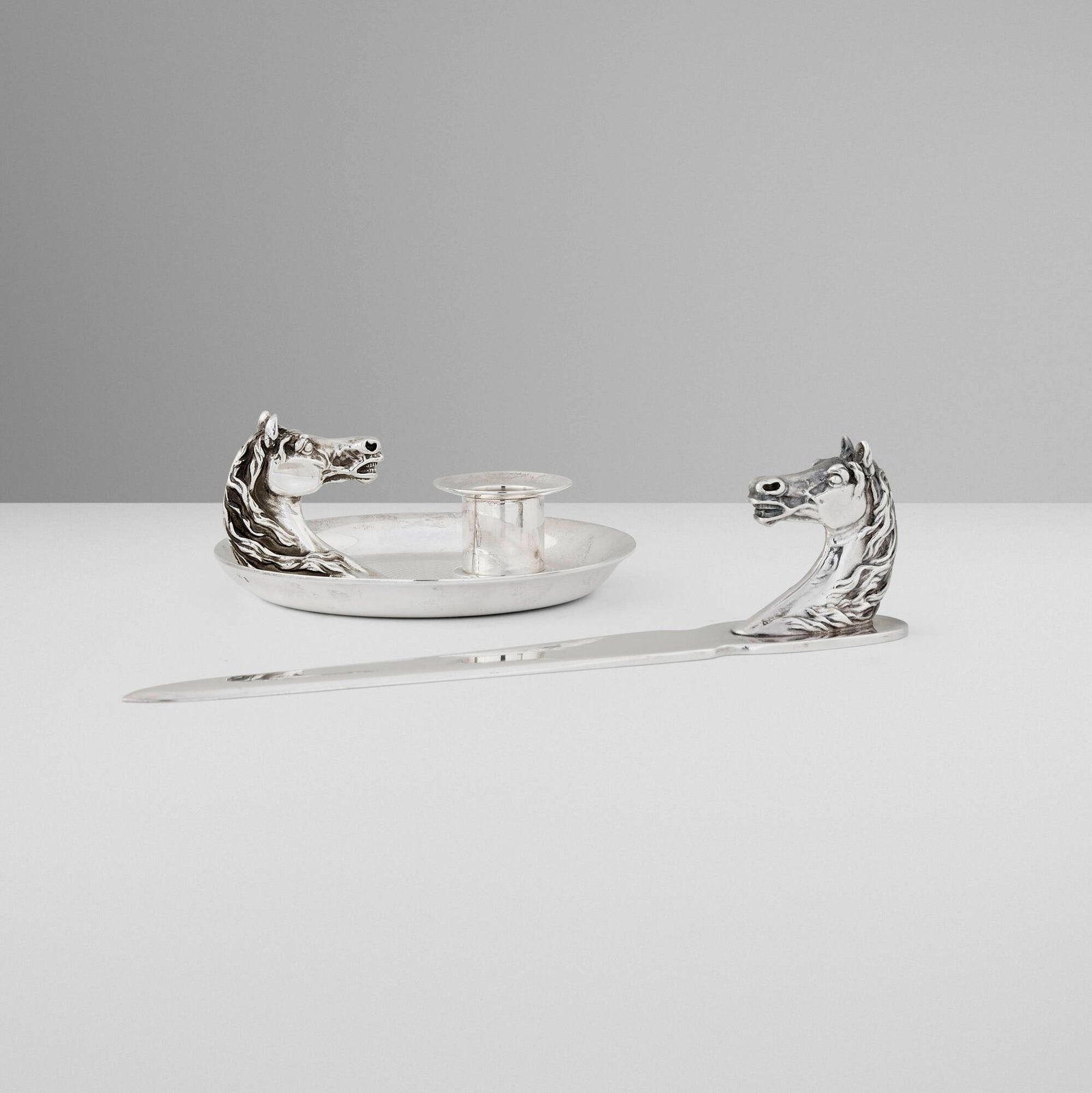 Hermes, Horse Head letter opener and candle holder: Hermes Horse Head letter opener and candle holder Ravinet d'Enfert & Cie France, c. 1965 silver-plated metal 2 h x 9 w x 1.5 d in (5 x 23 x 4 cm) 2 h x 4.75 dia in (5 x 12 cm) Impressed