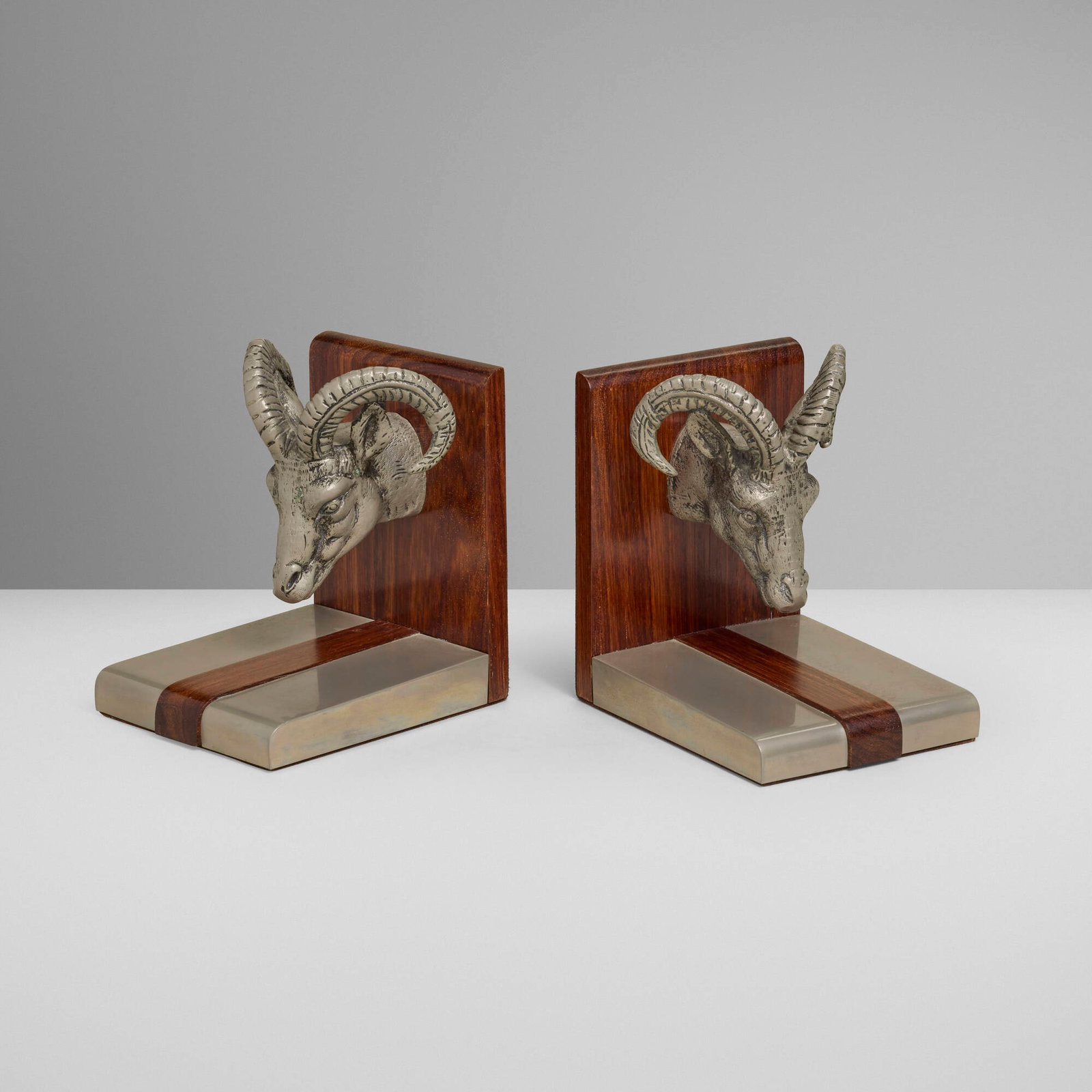 Gucci, Bookends with ram's heads, pair: Gucci Bookends with ram's heads, pair Italy, c. 1970 polished aluminum, cast metal, walnut, felt 6.125 h x 4.375 w x 5.625 d in (16 x 11 x 14 cm) Impressed manufacturer's mark to underside of