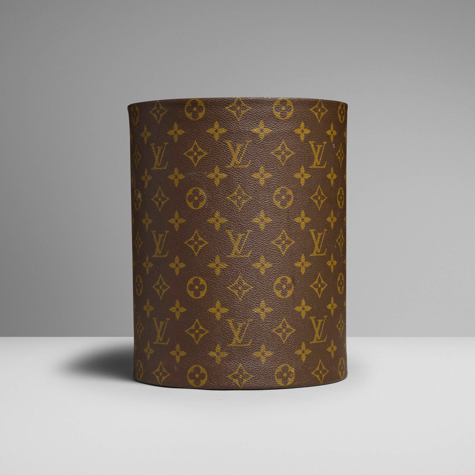 Louis Vuitton, Executive wastepaper basket: Louis Vuitton Executive wastepaper basket France, c. 1975 monogram coated canvas, leather, resin 10.25 h x 8 dia in (26 x 20 cm) This work will ship from Lambertville, New Jersey.