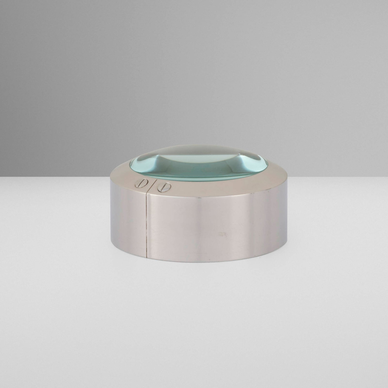 Cartier, Santos de Cartier magnifier paperweight: Cartier Santos de Cartier magnifier paperweight France / Switzerland, c. 2005 polished stainless steel, glass 1.375 h x 2.75 dia in (3 x 7 cm) Impressed manufacturer's mark to lower edge