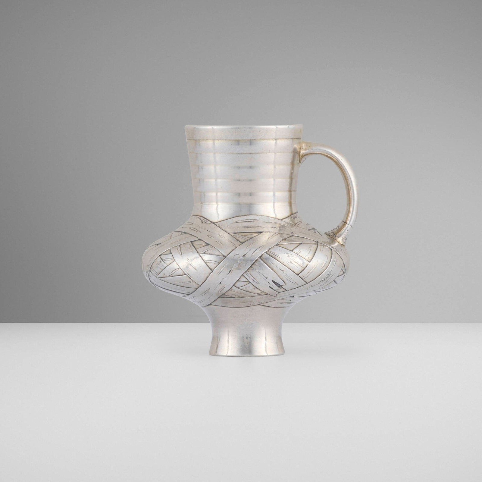 Russian, Trompe-l'oeil kvas jug: Russian Trompe-l'oeil kvas jug 1871 .875 silver 3.125 h x 2.875 w x 2.75 d in (8 x 7 x 7 cm) Jug features cast and chased basket weave pattern. Impressed assay marks with date to underside 'B.C