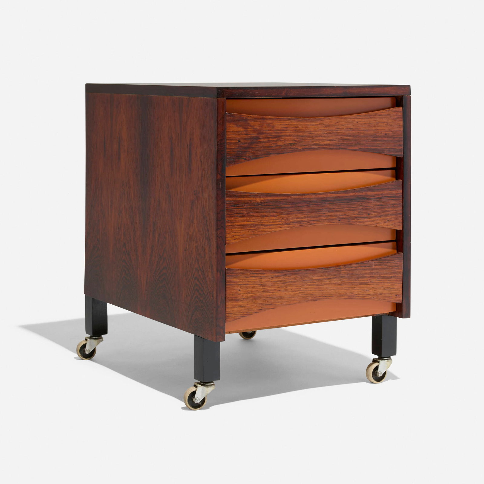 Danish Cabinetmaker, Rolling nightstand: Danish Cabinetmaker Rolling nightstand c. 1965 rosewood, painted wood 22.625 h x 16.75 w x 21.75 d in (57 x 43 x 55 cm) Nightstand features three drawers. This work will ship from Chicago, Illinois.