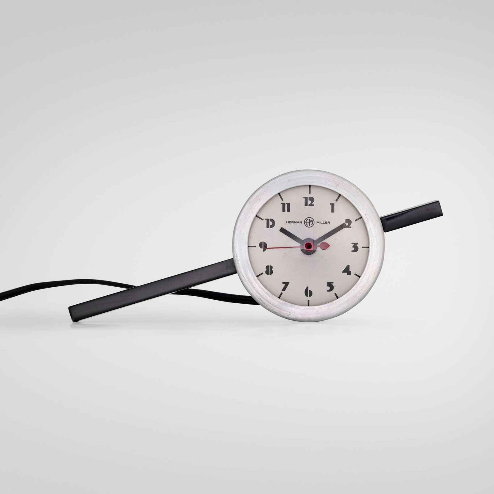 Gilbert Rohde, Table clock, model 6351: Gilbert Rohde Table clock, model 6351 Herman Miller Clock Company USA, c. 1935 enameled aluminum, aluminum, glass 3.5 h x 9 w x 2.625 d in (9 x 23 x 7 cm) Printed manufacturer's mark to face