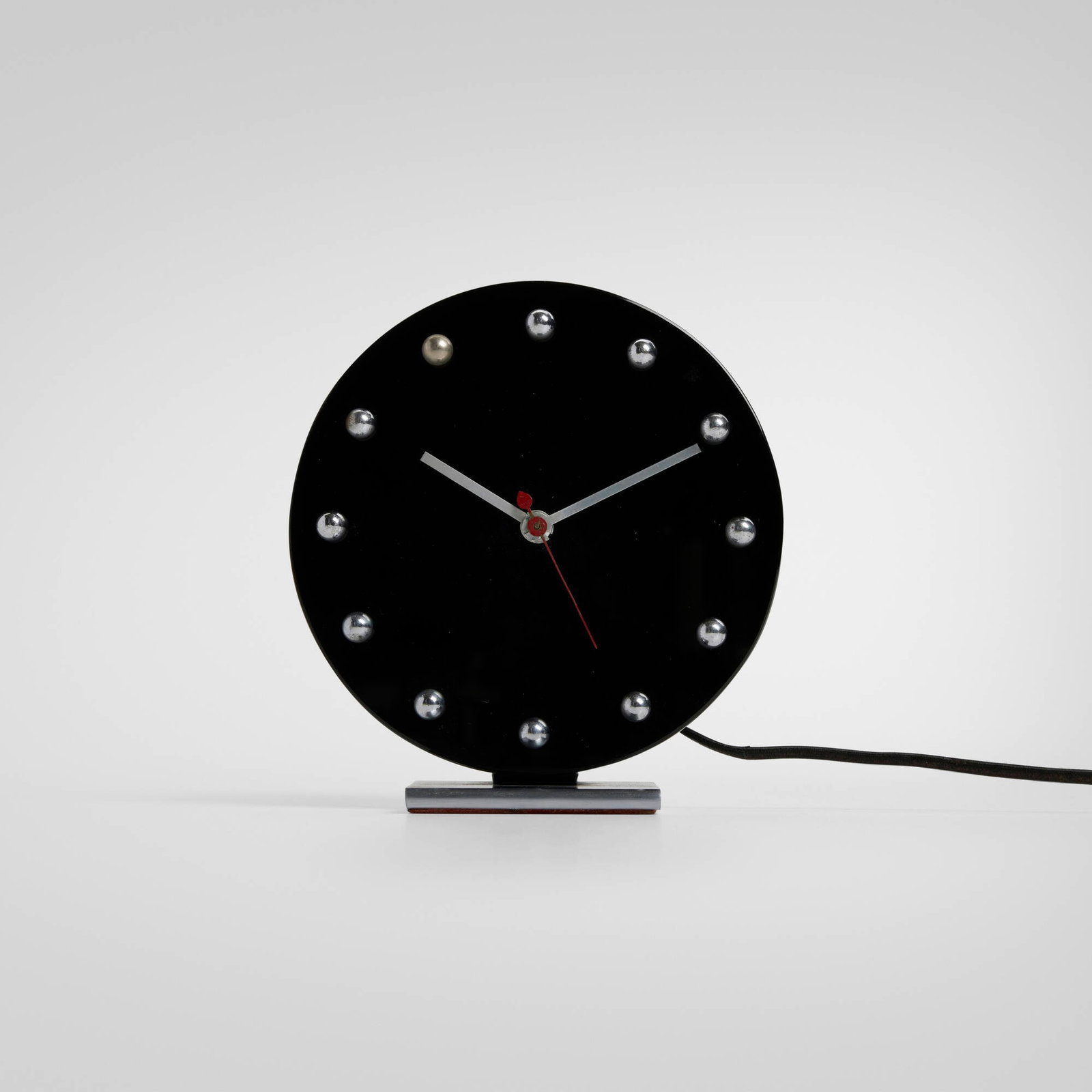 Gilbert Rohde, Table clock, model 4083A: Gilbert Rohde Table clock, model 4083A Herman Miller Clock Company USA, 1933 glass, chrome-plated brass, matte chrome-plated steel, aluminum 6.375 h x 5.875 w x 3 d in (16 x 15 x 8 cm) An example of