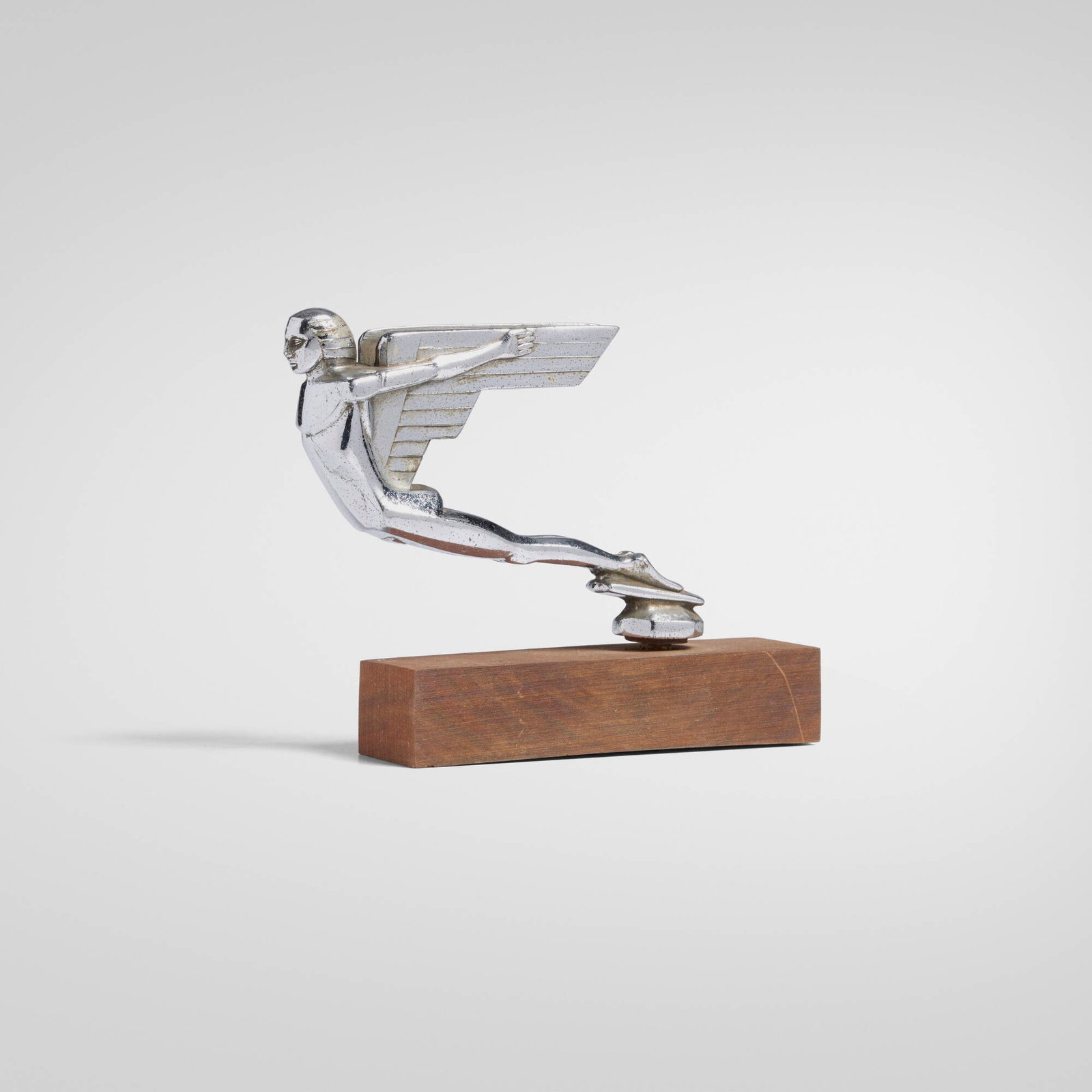 Machine Age, Winged Figure mascot: Machine Age Winged Figure mascot USA, c. 1930 chromed-plated metal, wood base 5.75 h x 6.75 w x 1.5 d in (15 x 17 x 4 cm) An example of this design is held in The Marvin Tamaroff Mascot Collection,