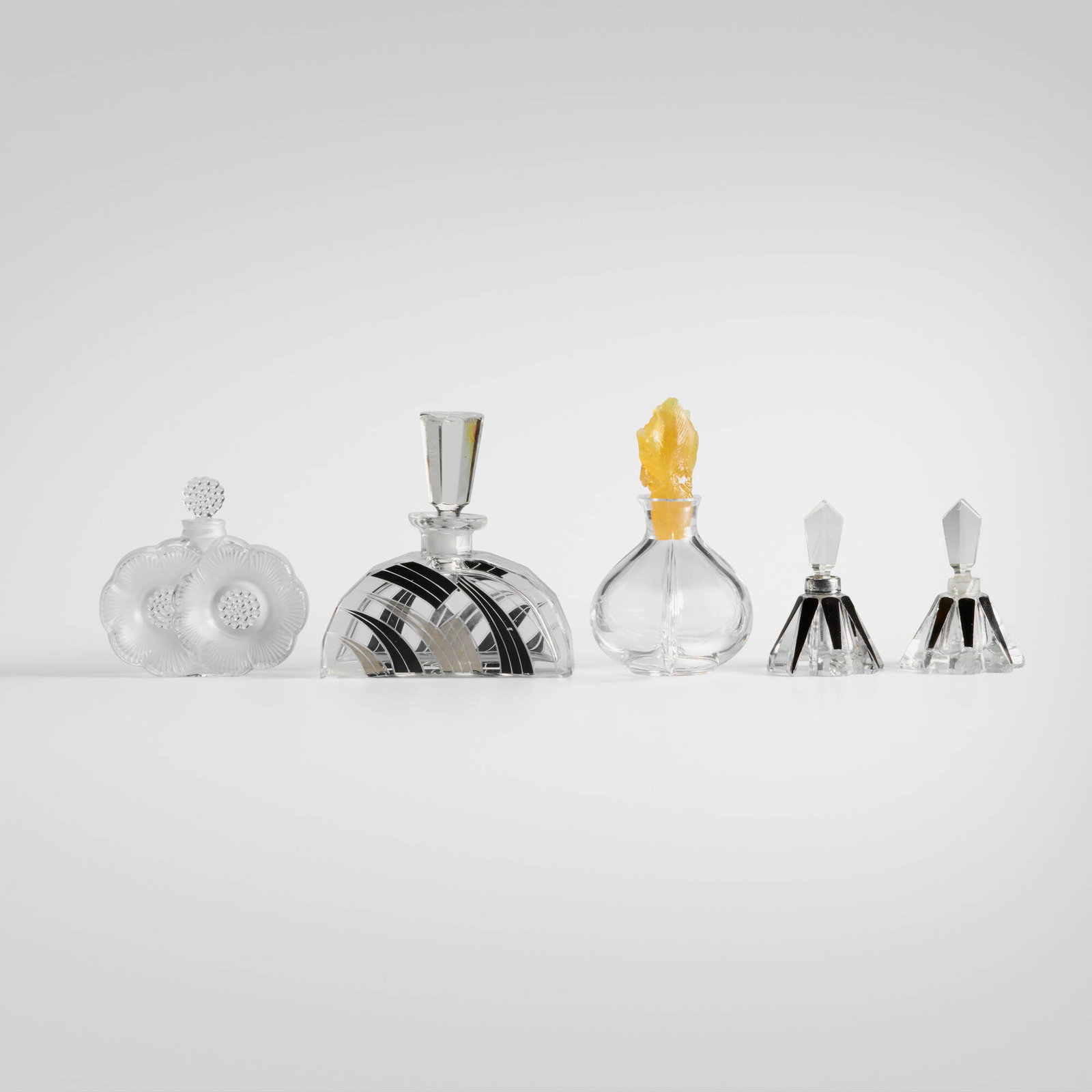 Collection of five perfume bottles: Collection of five perfume bottles c. 1935, c. 1975 crystal, pate de verre, silver, enamel largest: 4.75 h x 4.5 w x 1.75 d in (12 x 11 x 4 cm) smallest: 3.25 h x 2.375 dia in (8 x 6 cm) Collection