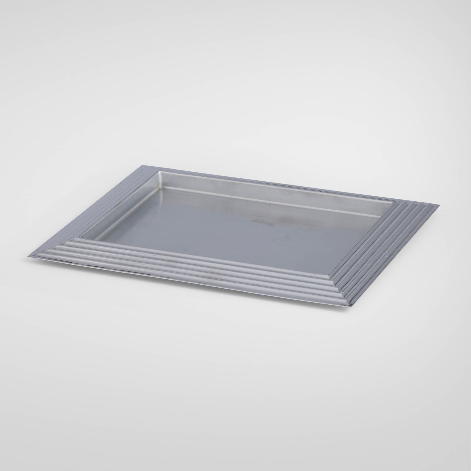 Norman Bel Geddes, Manhattan tray: Norman Bel Geddes Manhattan tray Revere Copper and Brass, Inc. USA, 1937 chrome-plated brass 1 h x 14.625 w x 11.625 d in (3 x 37 x 30 cm) An example of this design is in the permanent collection of