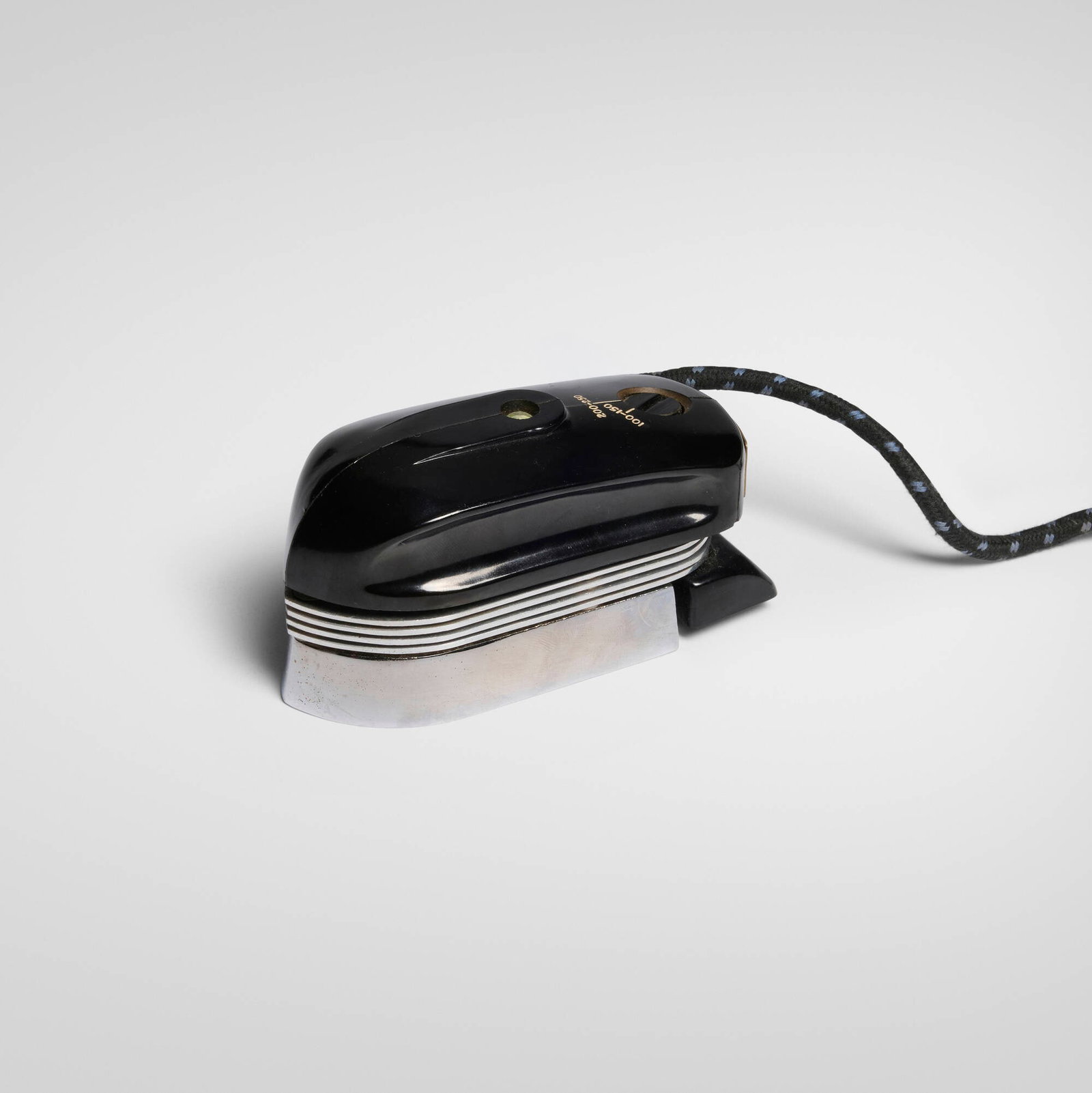 Lucas Holder, Smoothie portable iron: Lucas Holder Smoothie portable iron United Kingdom, 1946 Bakelite, enameled steel, cloth cord iron: 2.375 h x 4.5 w x 2 d in (6 x 11 x 5 cm) cord: 65 l in (165 cm) An example of this design is held
