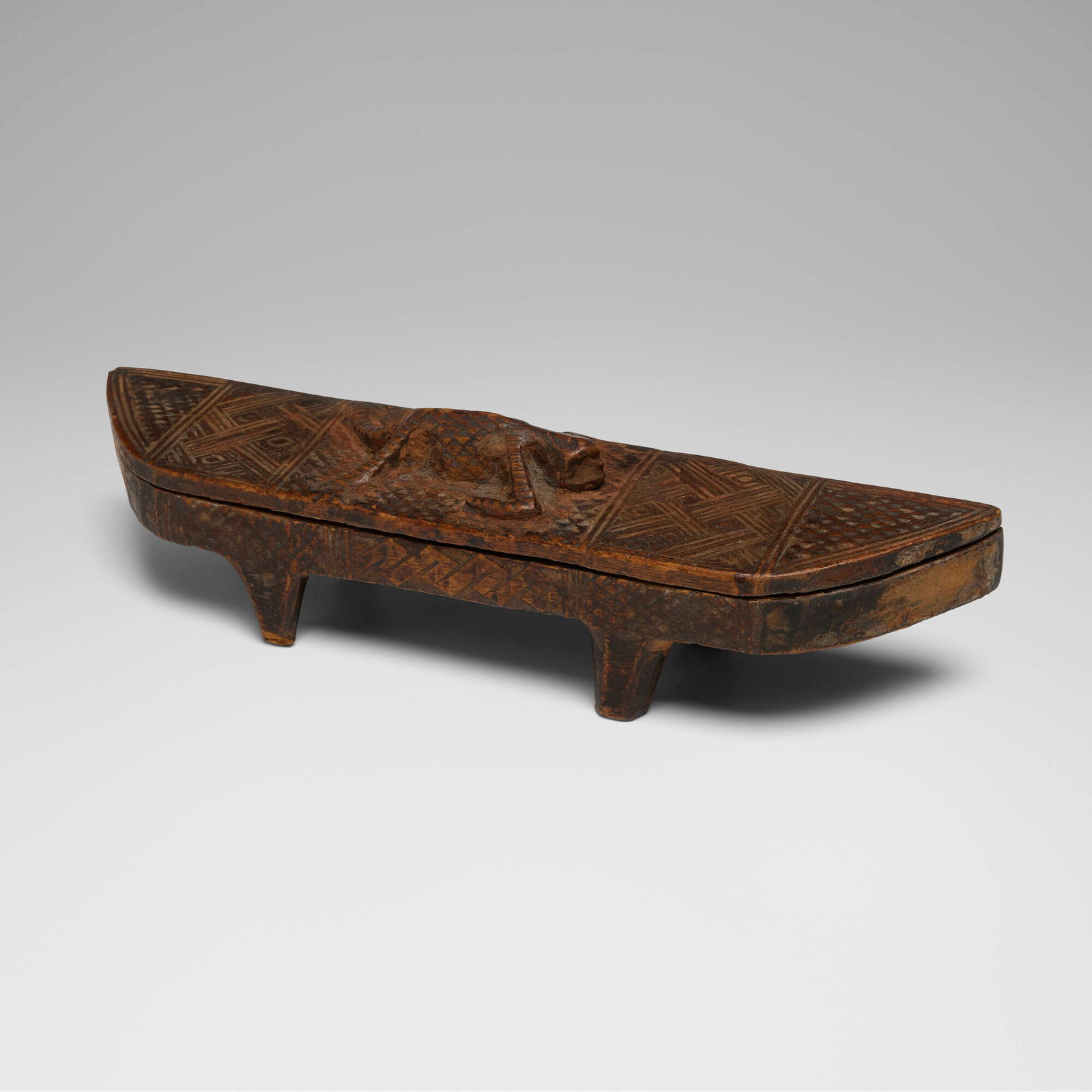 Bushongo (Kuba), Ngedi mu Ntey (cosmetic box): Bushongo (Kuba) Ngedi mu Ntey (cosmetic box) Democratic Republic of the Congo, Late 19th/early 20th century carved wood 3 h x 11.5 w x 2.5 d in (8 x 29 x 6 cm) This elegant half-moon-form cosmetic