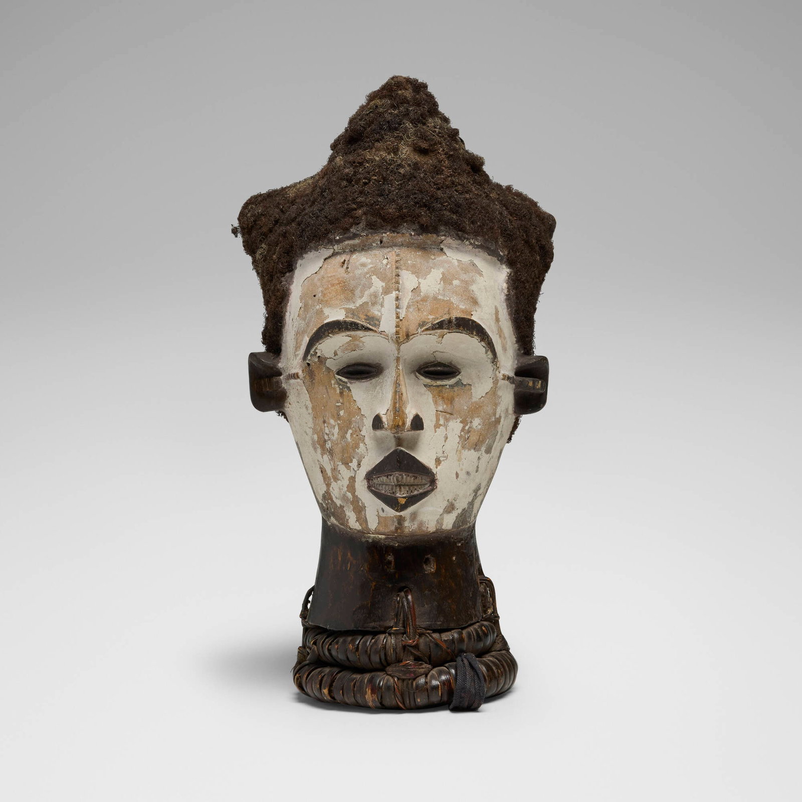 Igbo, Dance crest: Igbo Dance crest Nigeria, 20th century carved and blackened wood, kaolin, human hair, fiber, cloth 12.5 h x 6 dia in (32 x 15 cm) Provenance: Galerie Franke, Stuttgart | Priva