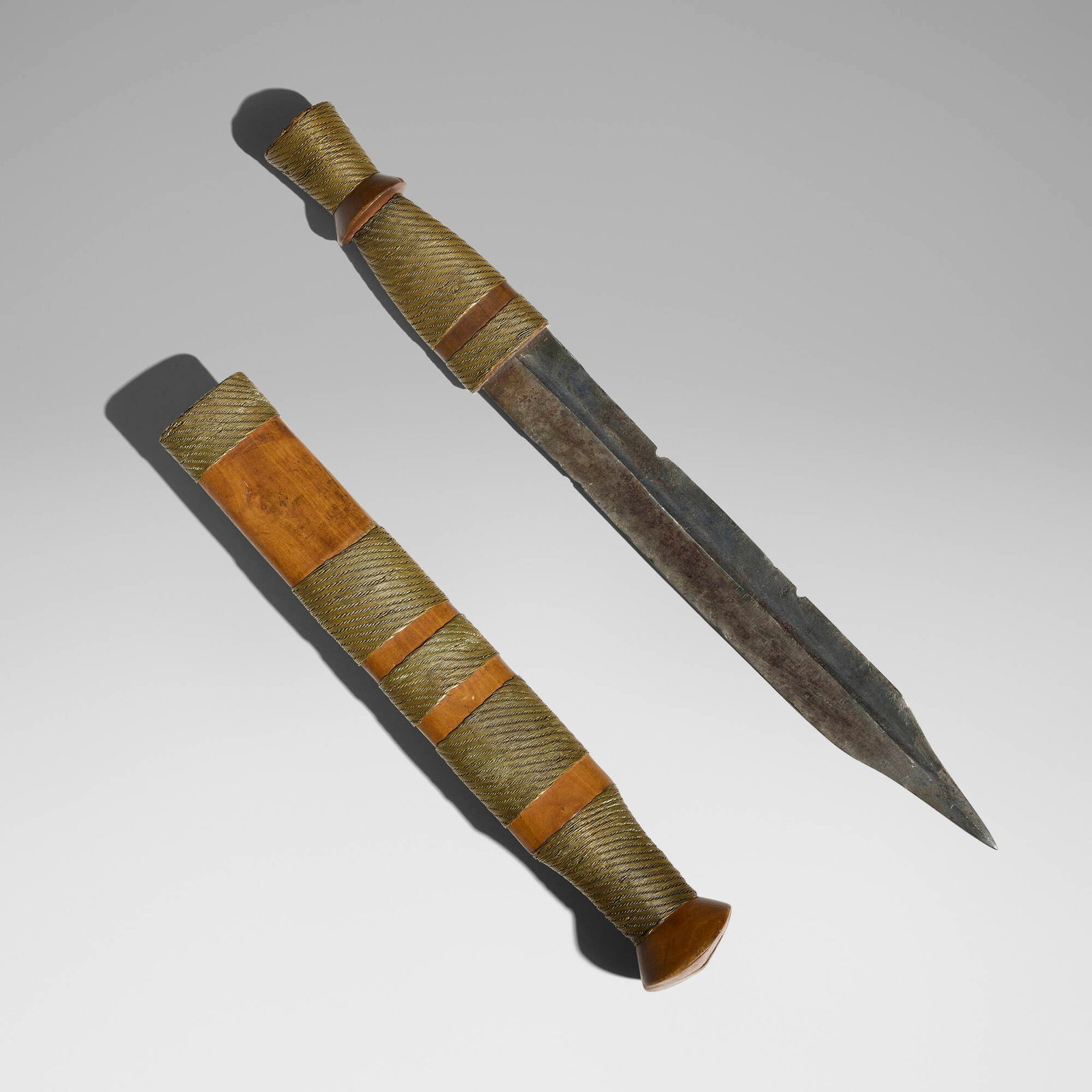 Shona, Bakatwa (sword or knife): Shona Bakatwa (sword or knife) Zimbabwe, 20th century carved wood, brass, steel 17 h x 1.5 w x 1.75 d in (43 x 4 x 4 cm) A superb bakatwa of light hardwood, chip-carved in sections between sheathed