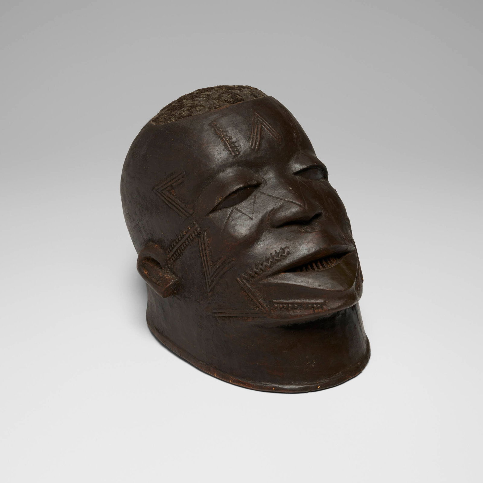 Makonde, Helmet mask: Makonde Helmet mask Tanzania, 20th century carved wood, hair 9.5 h x 11.5 w x 8 d in (24 x 29 x 20 cm) Provenance: Private Collection, Maryland This work wi