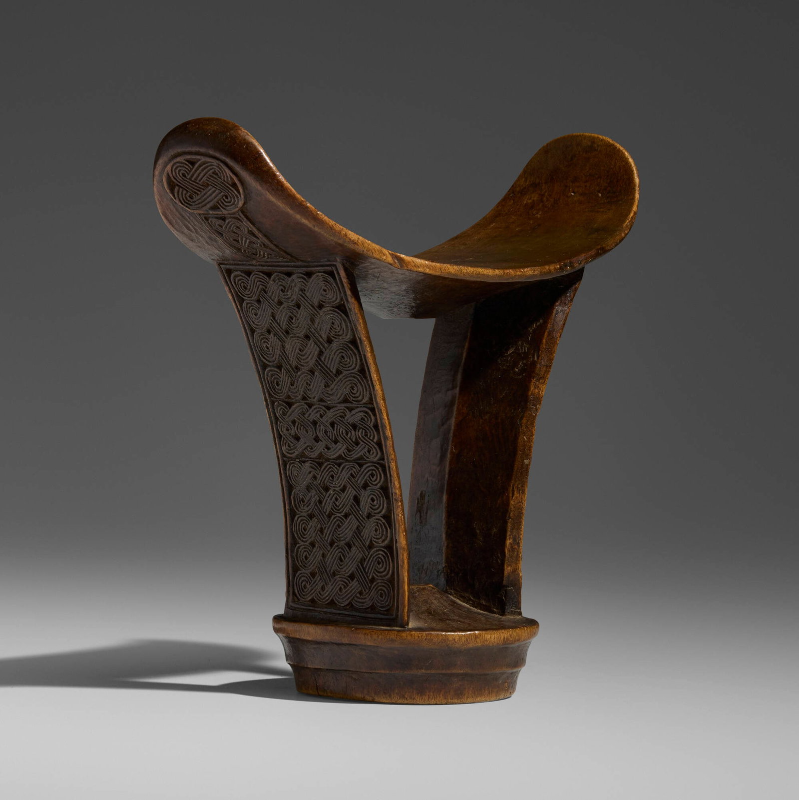 Somali, Barkin (Barshin) headrest: Somali Barkin (Barshin) headrest early 20th century carved wood 7.25 h x 7.25 w x 3.5 d in (18 x 18 x 9 cm) A superb example of a male elder's headrest featuring finely carved interlace m