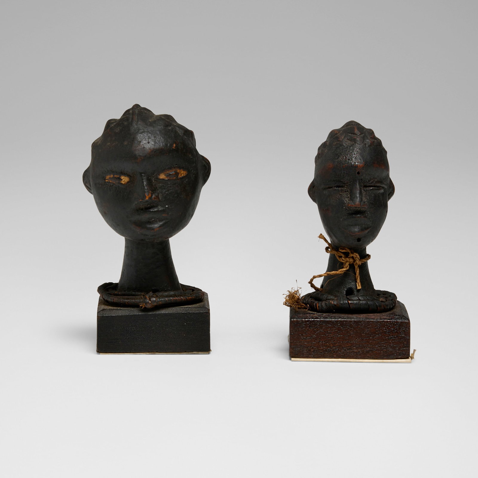 Anyang, Miniature ritual heads, set of two: Anyang Miniature ritual heads, set of two Southeastern Nigeria, early 20th century antelope skin over carved wood, raffia 5 h x 2.5 w x 3 d in (13 x 6 x 8 cm) 4.5 h x 2.5 w x 2.5 d in (11 x 6 x 6 cm)