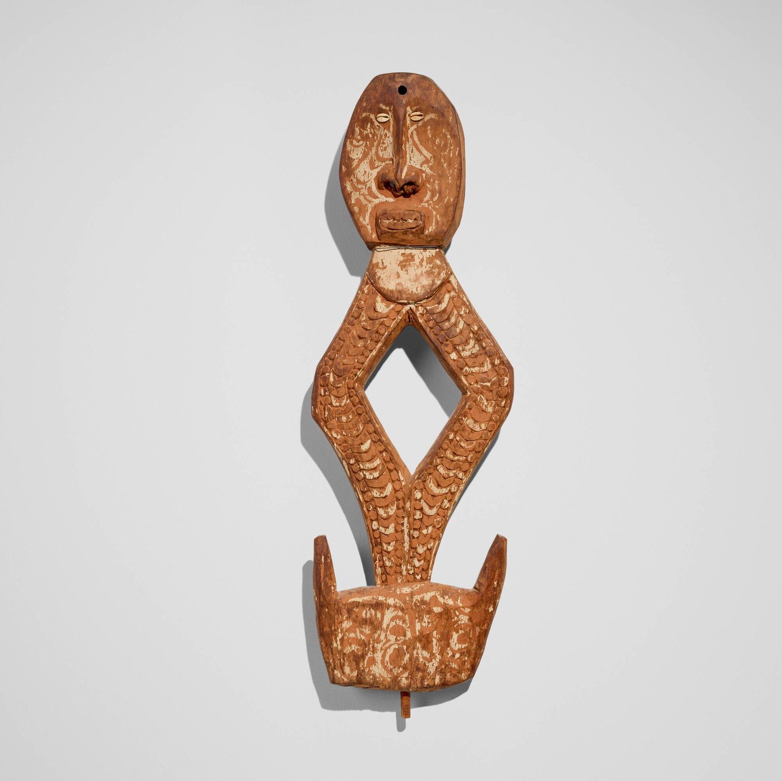 Iatmul, Suspension hook figure: Iatmul Suspension hook figure New Guinea, c. 1930 carved wood, pigment, cowrie shells 33 h x 10.5 w x 3 d in (84 x 27 x 8 cm) Provenance: Private Collection, San Marino, CA This work will ship from