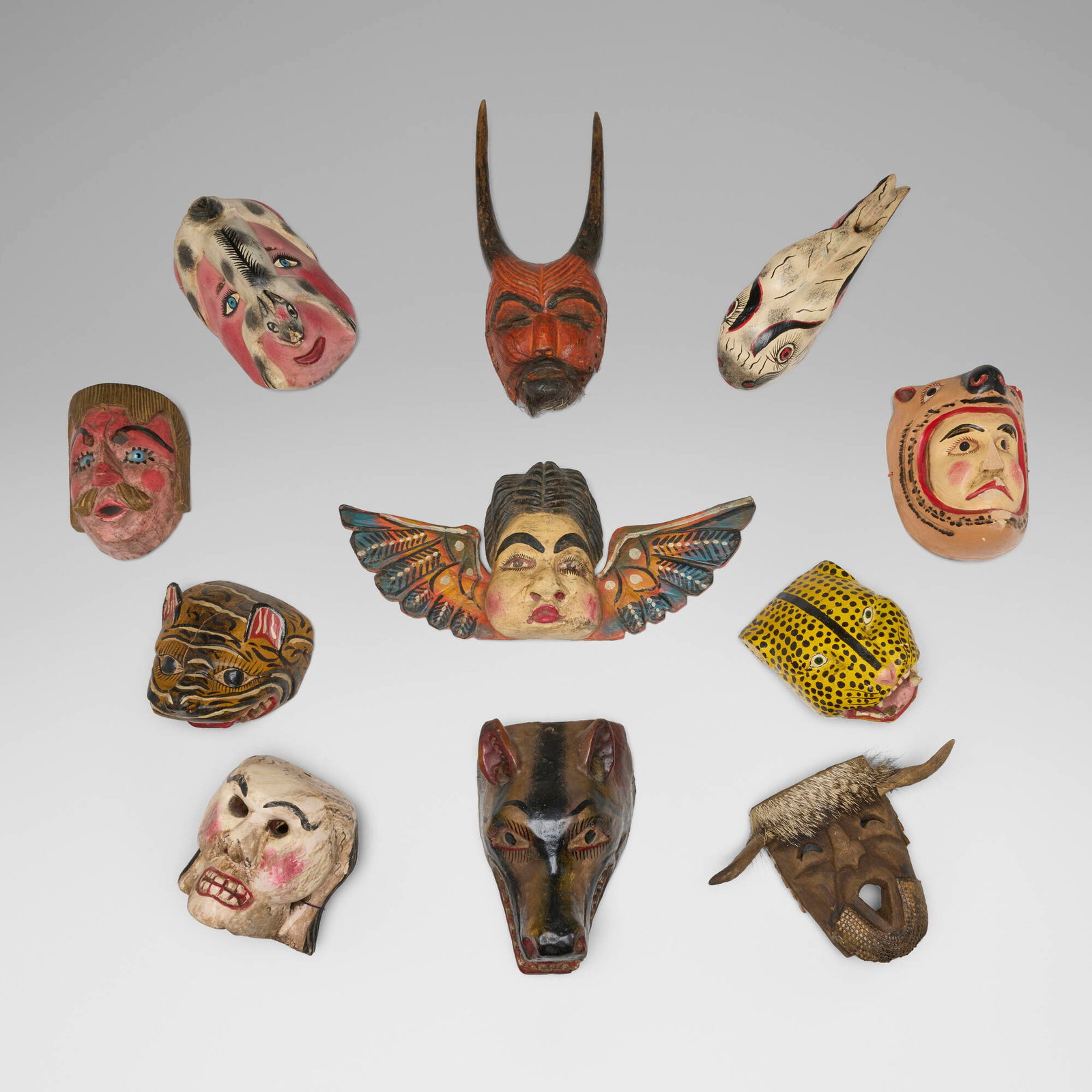 Mexican, Collection of eleven festival masks: Mexican Collection of eleven festival masks 20th century carved and painted wood largest: 9 h x 19 w x 4 d in (23 x 48 x 10 cm) smallest: 8 h x 6 w x 6 d in (20 x 15 x 15 cm) Provenance: Collected in