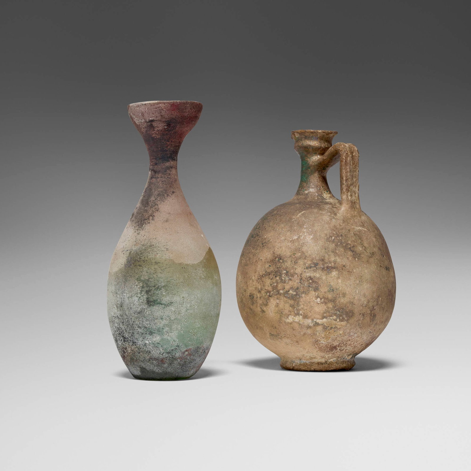 Roman, Vessels, set of two: Roman Vessels, set of two c. 1st-3rd century CE blown glass 12.5 h x 5.25 dia in (32 x 13 cm) 12 h x 7.57 dia in (30 x 19 cm) Provenance: Private Collection, California This work will ship from Los