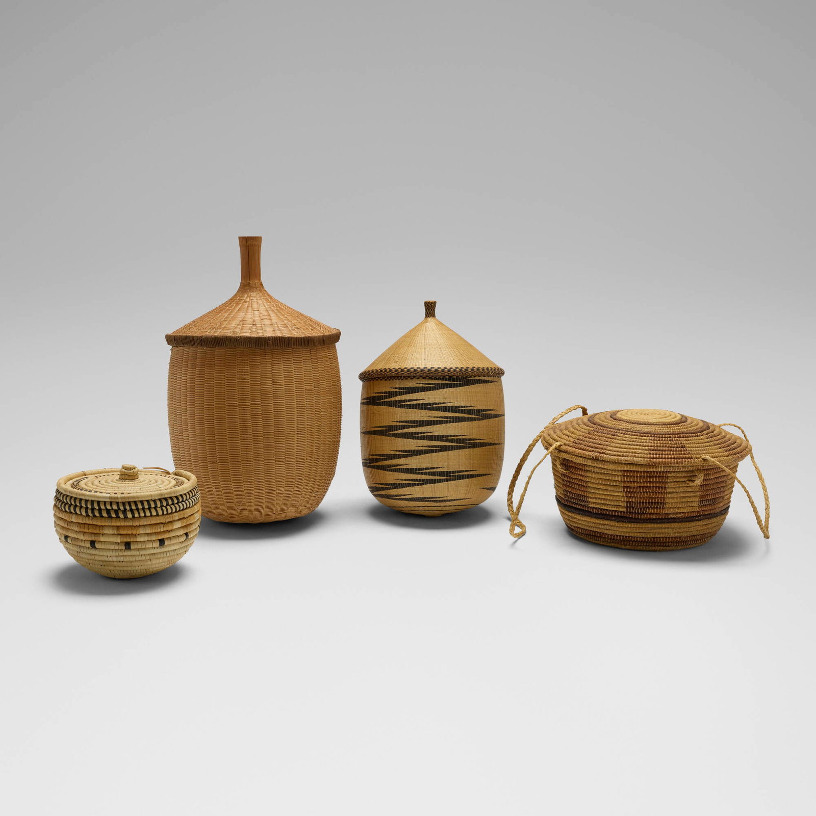 African, Collection of four baskets: African Collection of four baskets 20th century reed, cane largest: 22 h x 13 dia in (56 x 33 cm) smallest: 8 h x 9.5 dia in (20 x 24 cm) Lot includes a Zulu ukhamba beer vessel and small lidded