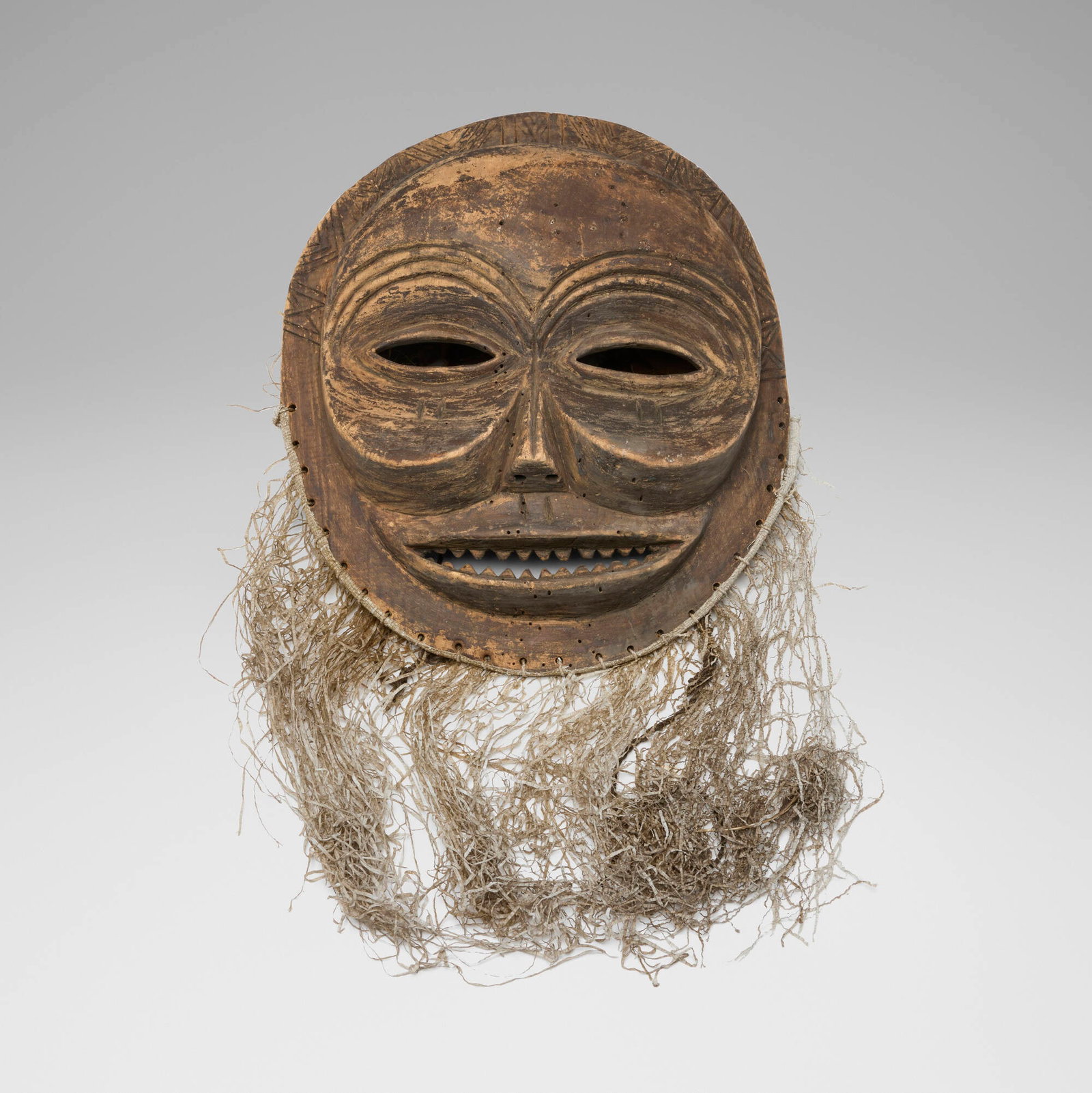 Mbunda, Sachihongo mask: Mbunda Sachihongo mask Angola, 20th century carved wood, raffia, string, feathers, synthetic fibers 21 h x 20 w x 8 d in (53 x 51 x 20 cm) These large and dramatic masks are characterized by enlarged