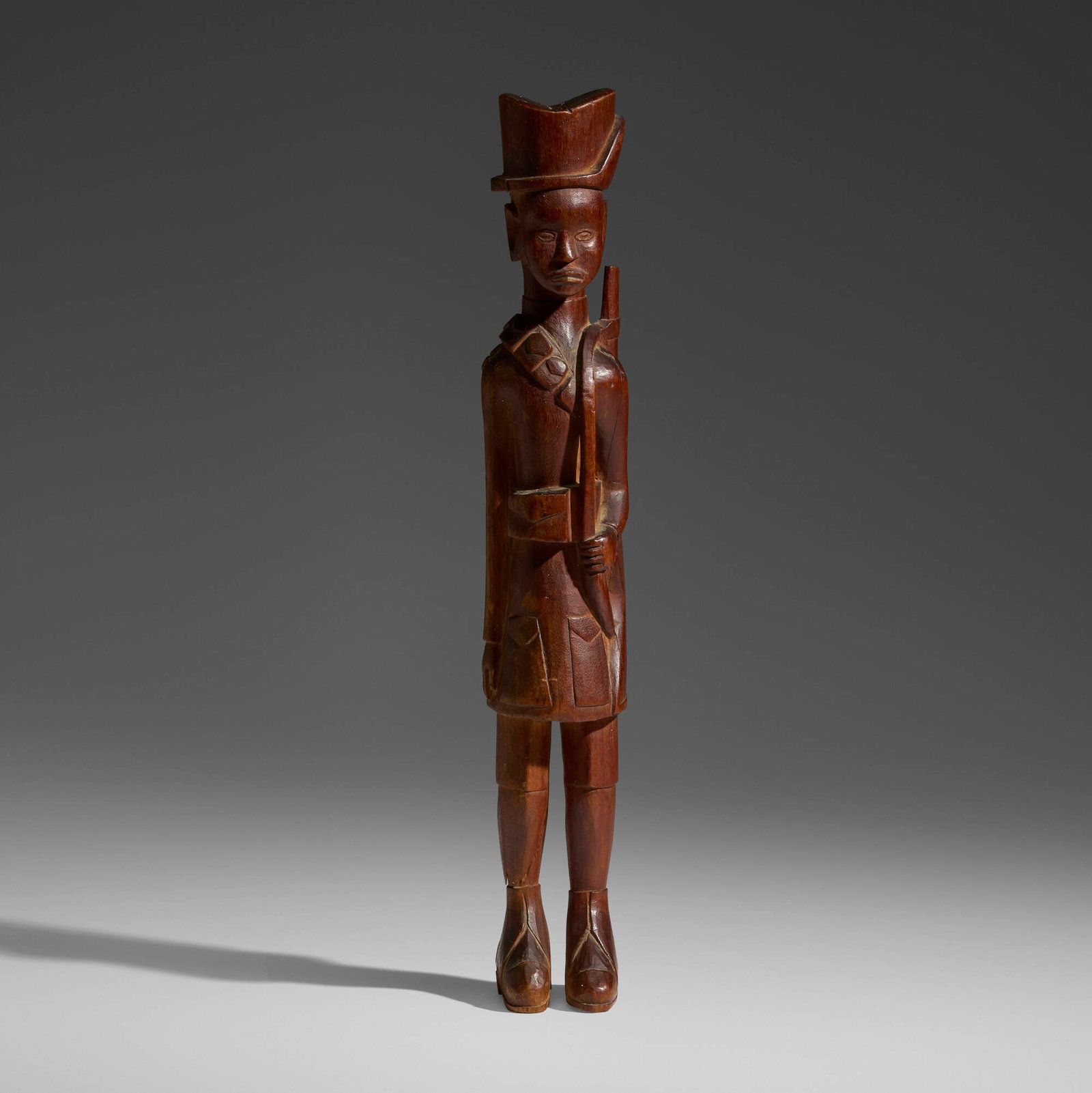Kamba, Askari figure: Kamba Askari figure Kenya, 20th century carved wood 17 h x 3 dia in (43 x 8 cm) A large colonial-era figure, finely detailed with fire-darkened elements, wearing the slouch hat of the King'