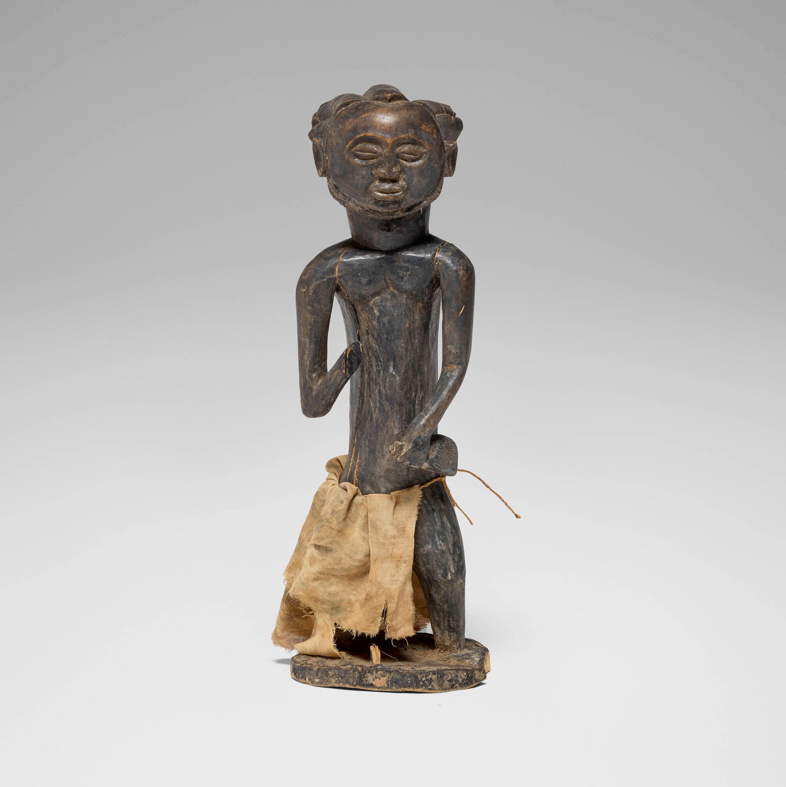 Hemba, Male figure: Hemba Male figure Democratic Republic of the Congo, 20th century carved wood, muslin cloth 17.5 h x 6 w x 5.5 d in (44 x 15 x 14 cm) Provenance: The Sam and Beverly Maloof Collection This work will