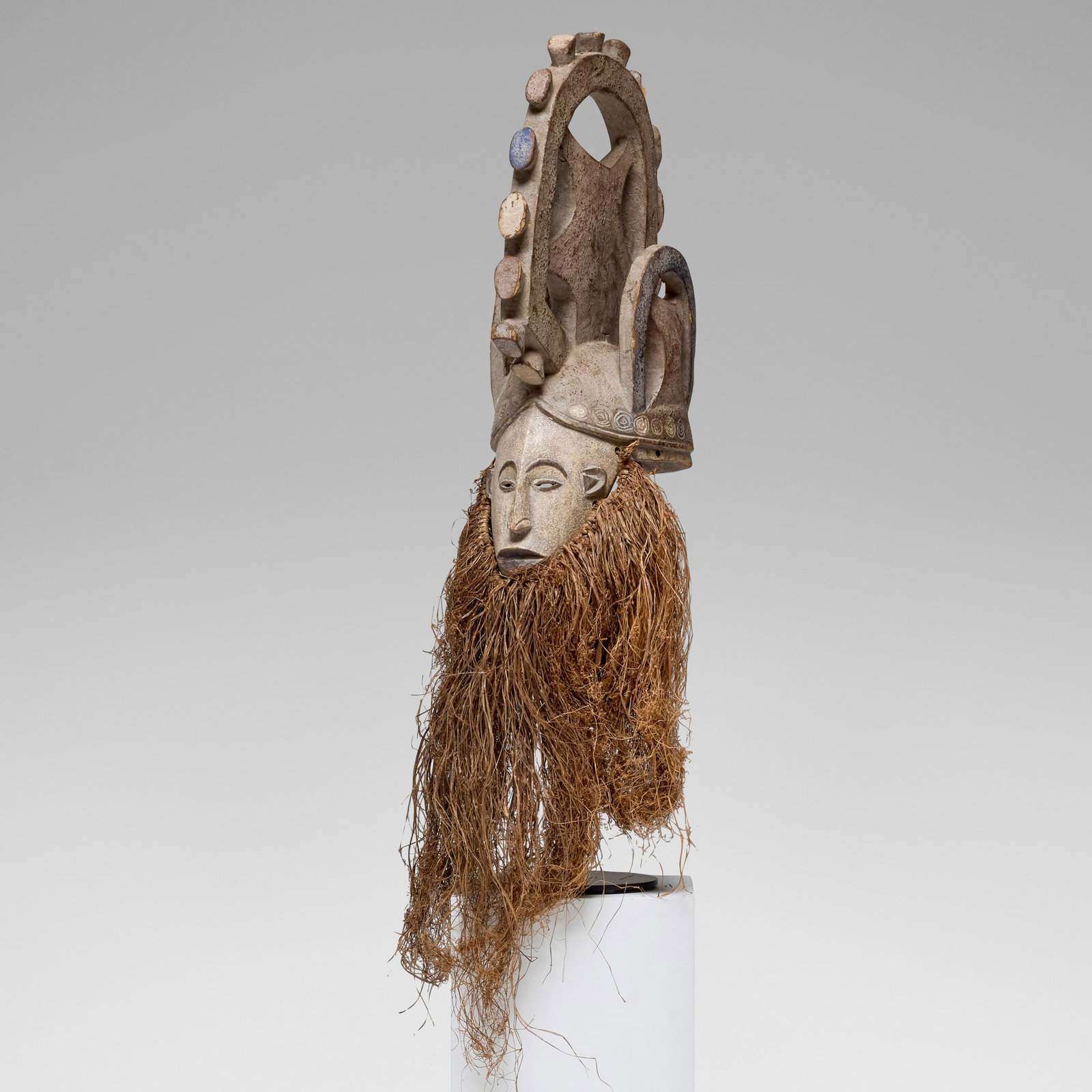 Igbo, Agbogbo Mmuo (white spirit or maiden) mask: Igbo Agbogbo Mmuo (white spirit or maiden) mask Nigeria, late 20th century carved wood, pigment, raffia 48 h x 8 w x 13 d in (122 x 20 x 33 cm) Provenance: The Sam and Beverly Maloof Collection This