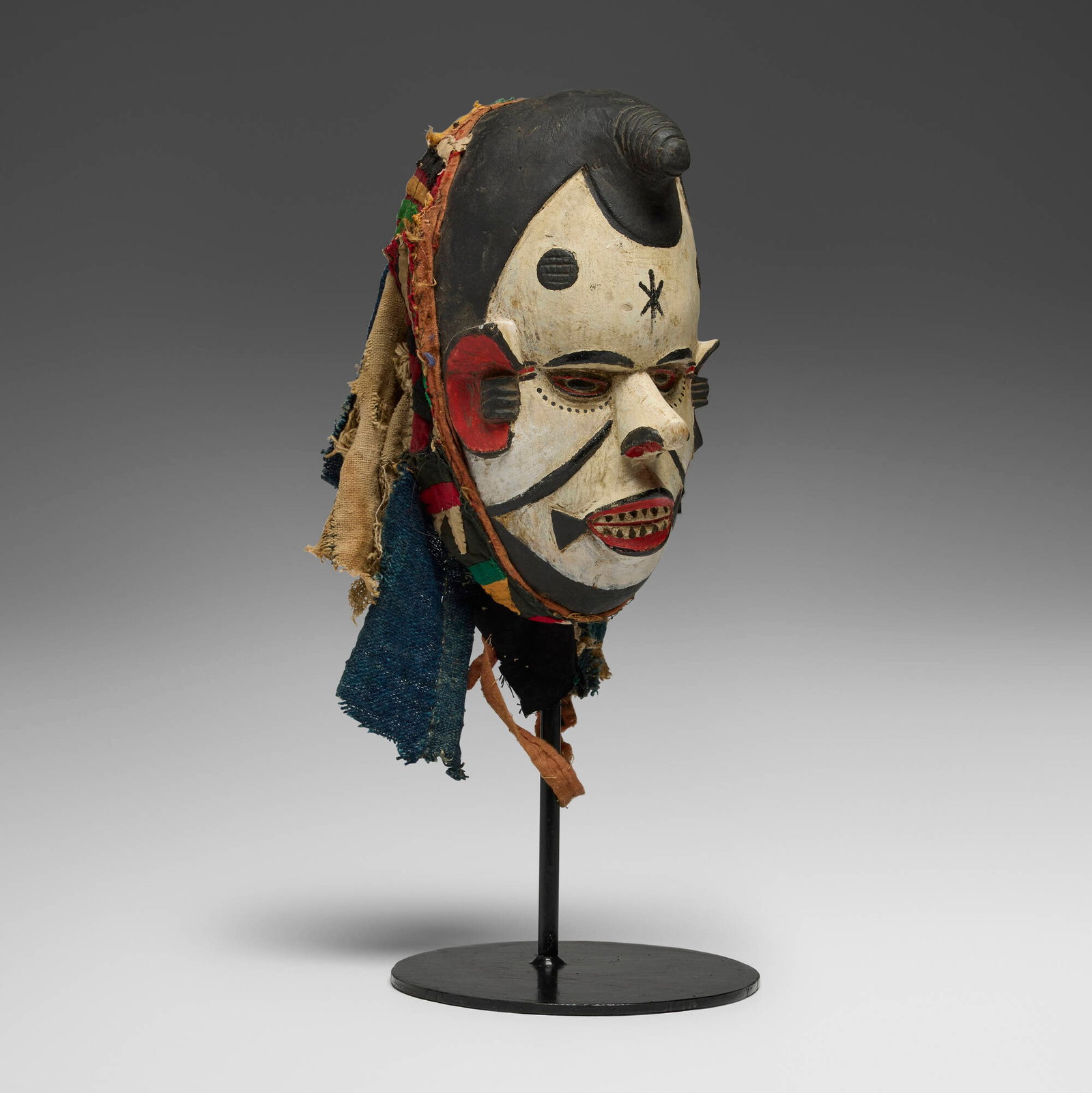 Igbo, Agbogbo Mmuo (white spirit or maiden) mask: Igbo Agbogbo Mmuo (white spirit or maiden) mask Nigeria, 20th century painted wood, cloth 12 h x 8 w x 7 d in (30 x 20 x 18 cm) Provenance: Private Collection, Maryland This work will ship from