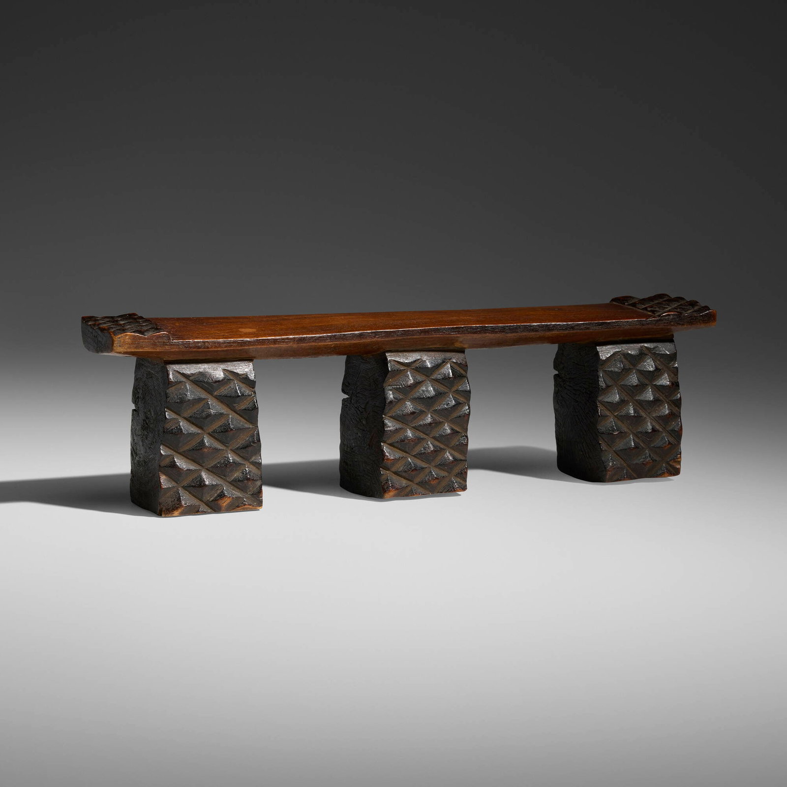 Zulu, Headrest: Zulu Headrest South Africa, 20th century carved wood 4.5 h x 16 w x 3 d in (11 x 41 x 8 cm) This three-legged Zulu headrest is richly carved with amasumpa motifs on the legs and at either end of the