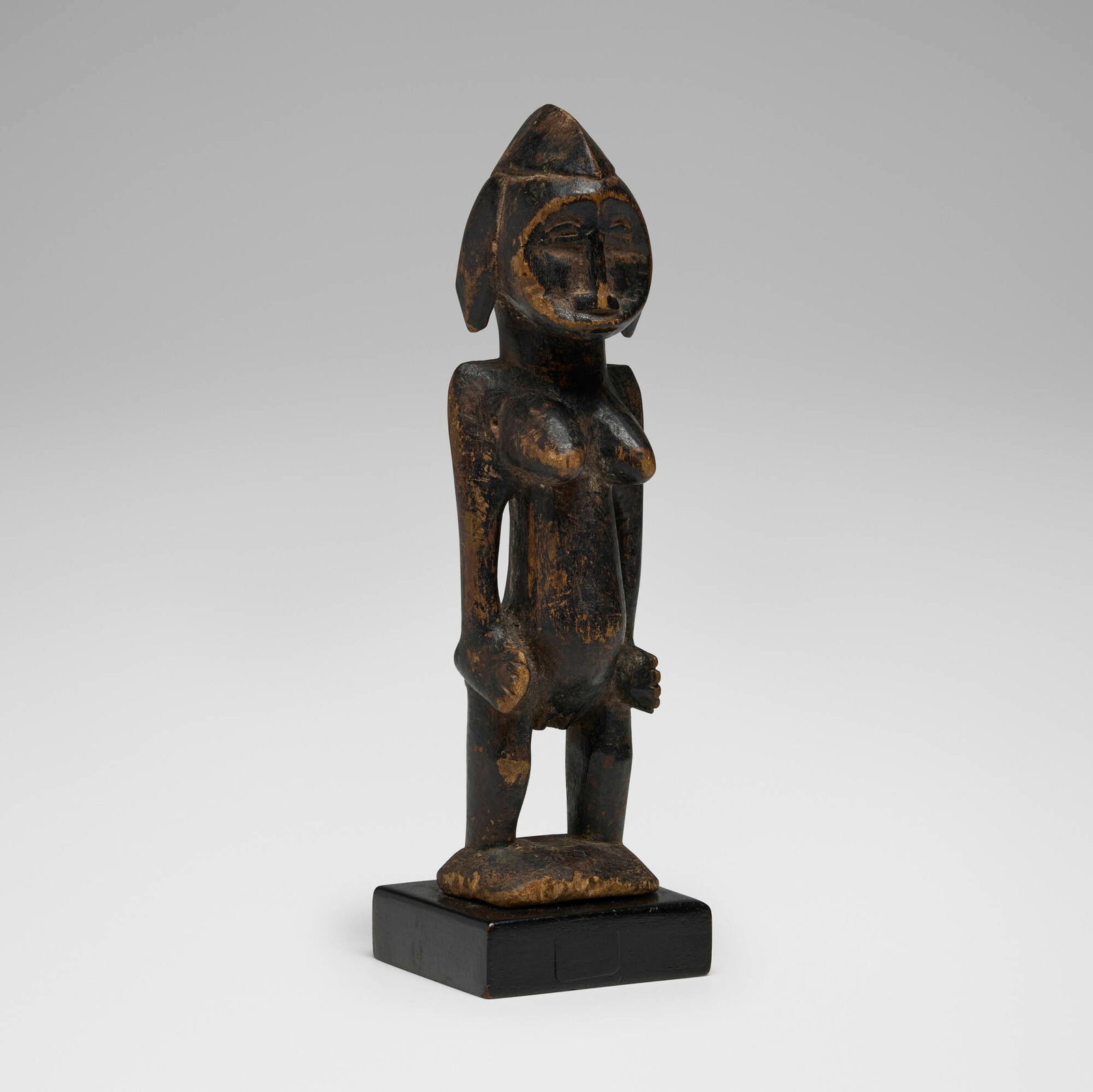 Senufo, Female Pombia figure: Senufo Female Pombia figure Cote d'Ivoire, 20th century carved wood 9.25 h x 2.75 w x 2.5 d in (23 x 7 x 6 cm) Provenance: Private Collection This work will ship from Chicago, Illinois.