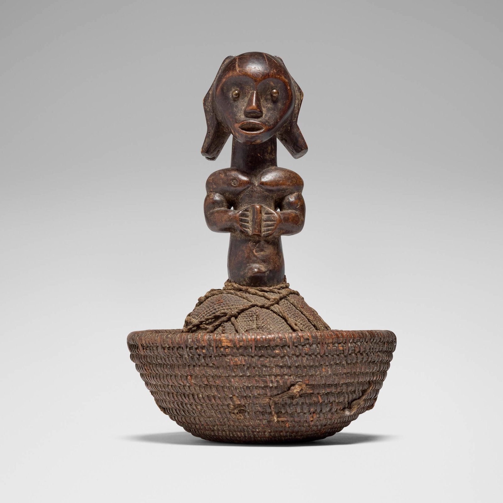 Fang, Reliquary guardian figure with basket: Fang Reliquary guardian figure with basket Gabon, 20th century carved wood, plant fiber 13 h x 8.25 dia in (33 x 21 cm) This work will ship from Los Angeles, California.