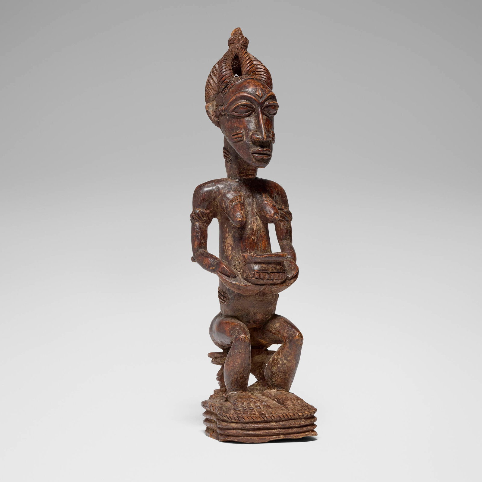 Baule, Seated female figure: Baule Seated female figure Cote d'Ivoire, first half 20th century carved wood 20.25 h x 5 w x 6 d in (51 x 13 x 15 cm) Provenance: Private Collection, San Marino, CA This work will ship from Los