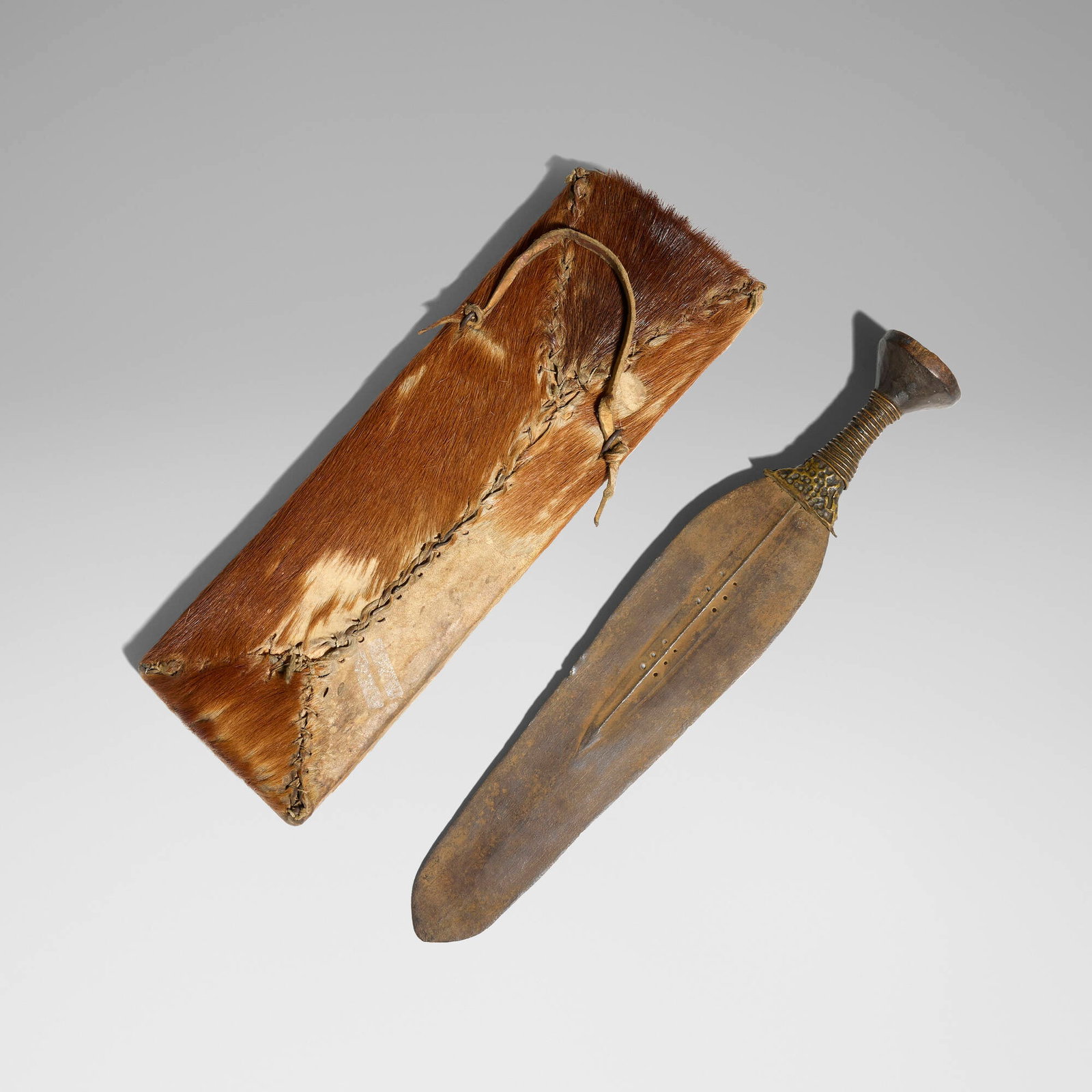 Mongo, Konda (short sword) with intact scabbard: Mongo Konda (short sword) with intact scabbard Democratic Republic of the Congo, 20th century carved wood, brass, antelope skin 22 h x 6 w x 2.25 d in (56 x 15 x 6 cm) The central ridge of this