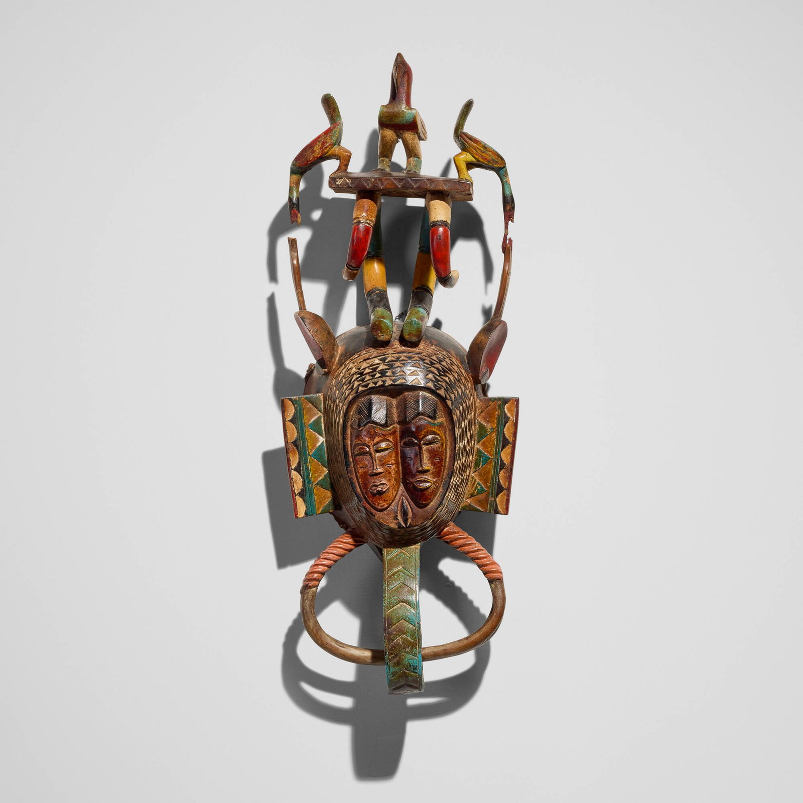 Guro, Janus mask: Guro Janus mask Cote d'Ivoire, c. 1980 painted and carved wood, plant fiber 27.5 h x 10 w x 5.5 d in (70 x 25 x 14 cm) Provenance: Private Collection, San Marino, CA This work will ship from Los